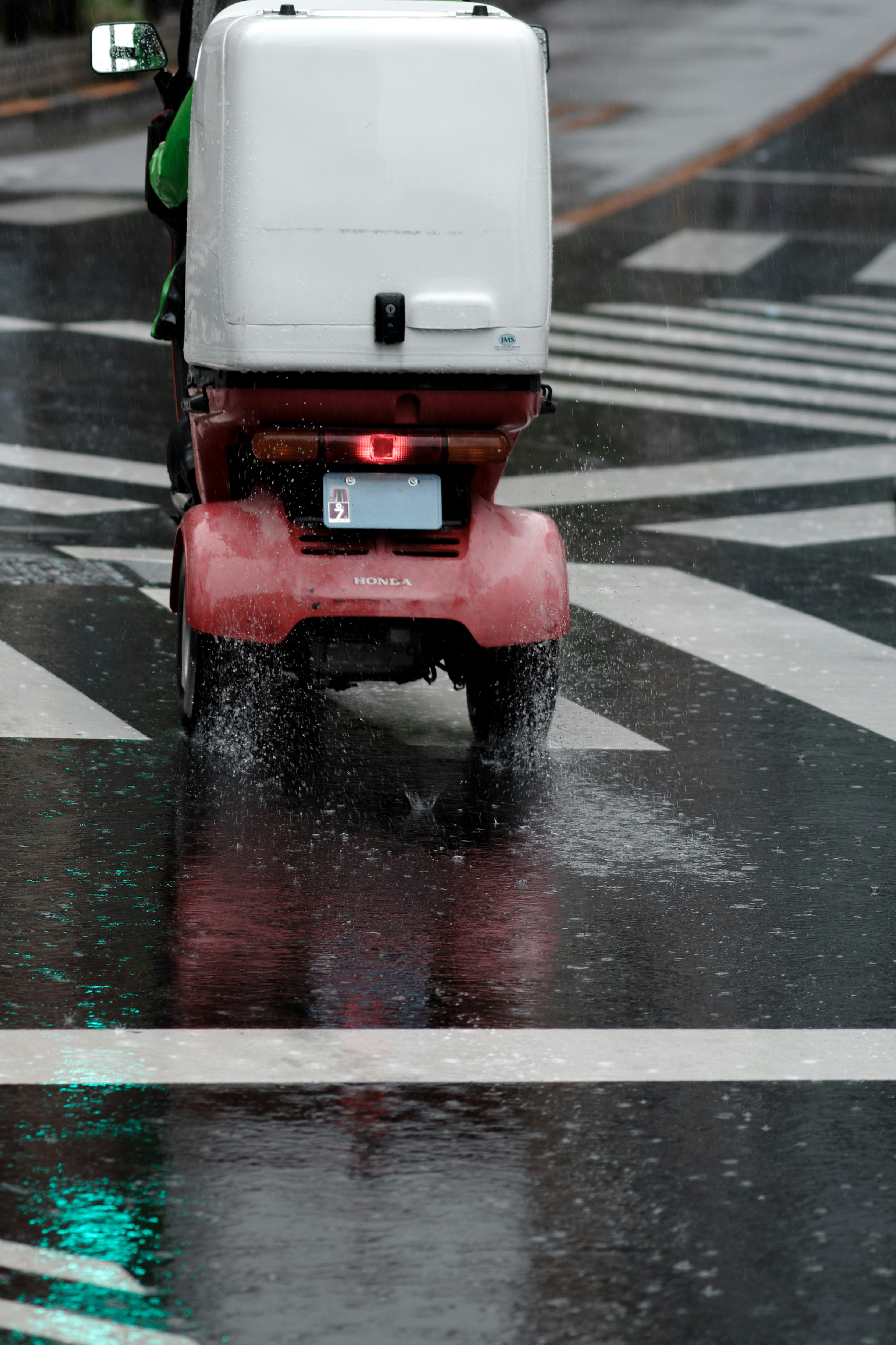 vue arrière d’un scooter projetant de l’eau