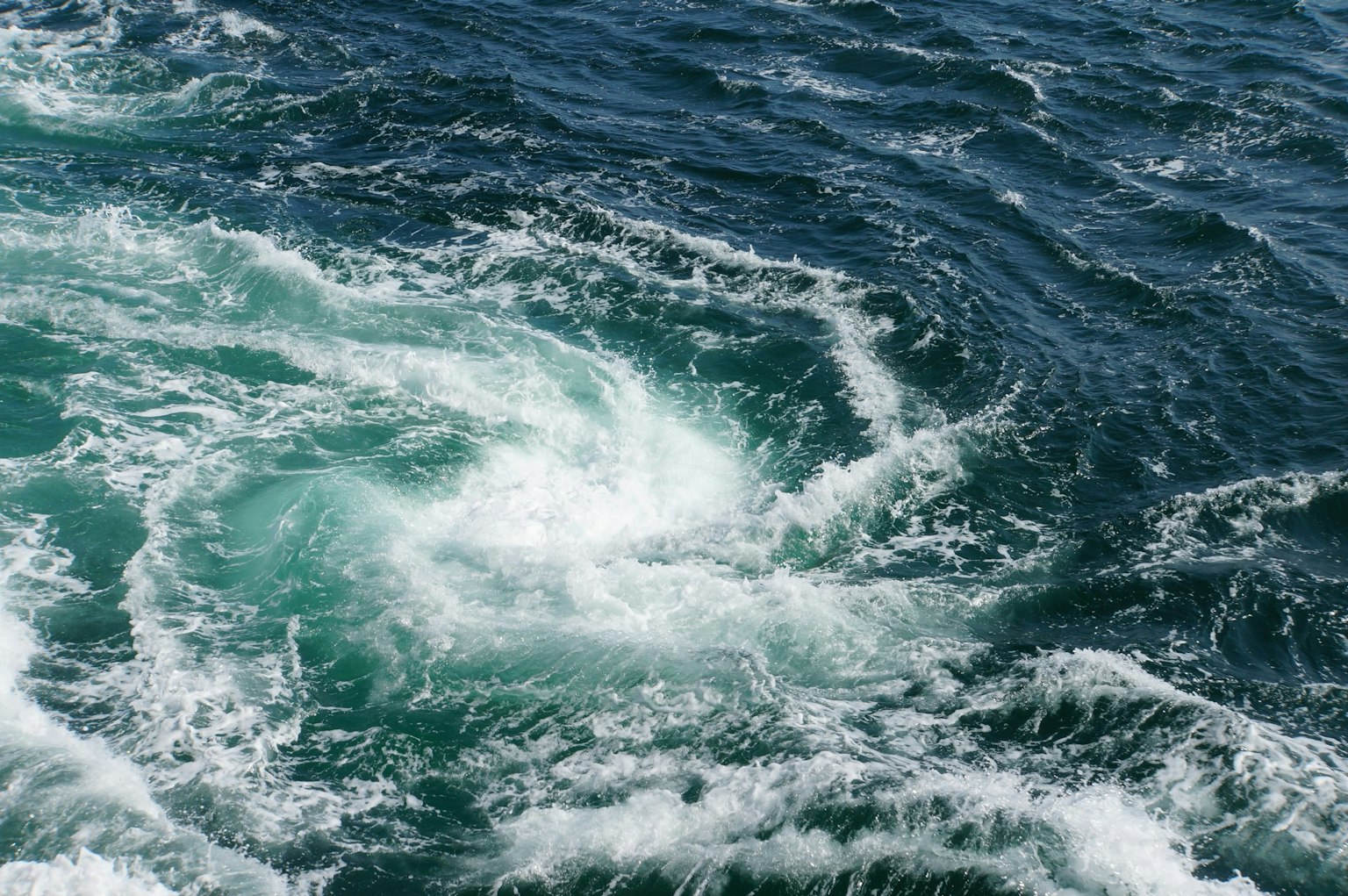 Surface d'eau tourbillonnante avec des nuances de bleu et de vert