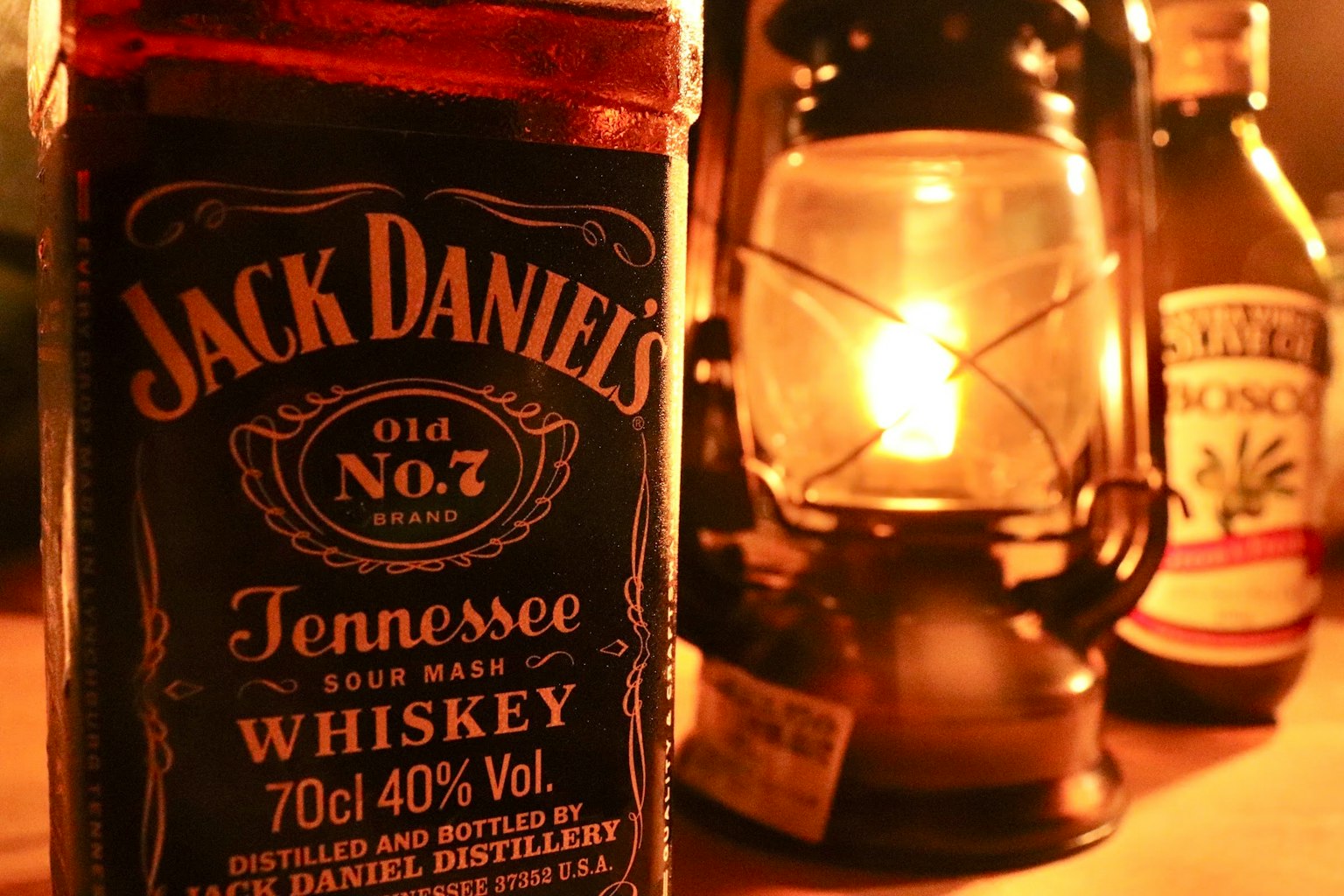 Bottiglia di whiskey Jack Daniel's con una lanterna in un ambiente caldo
