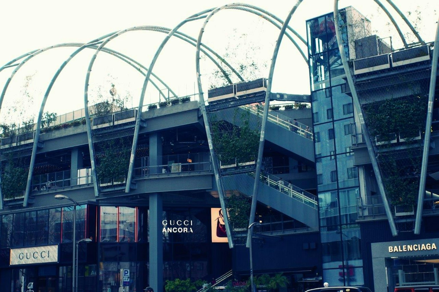 Extérieur d'un centre commercial moderne avec des boutiques Gucci et Balenciaga