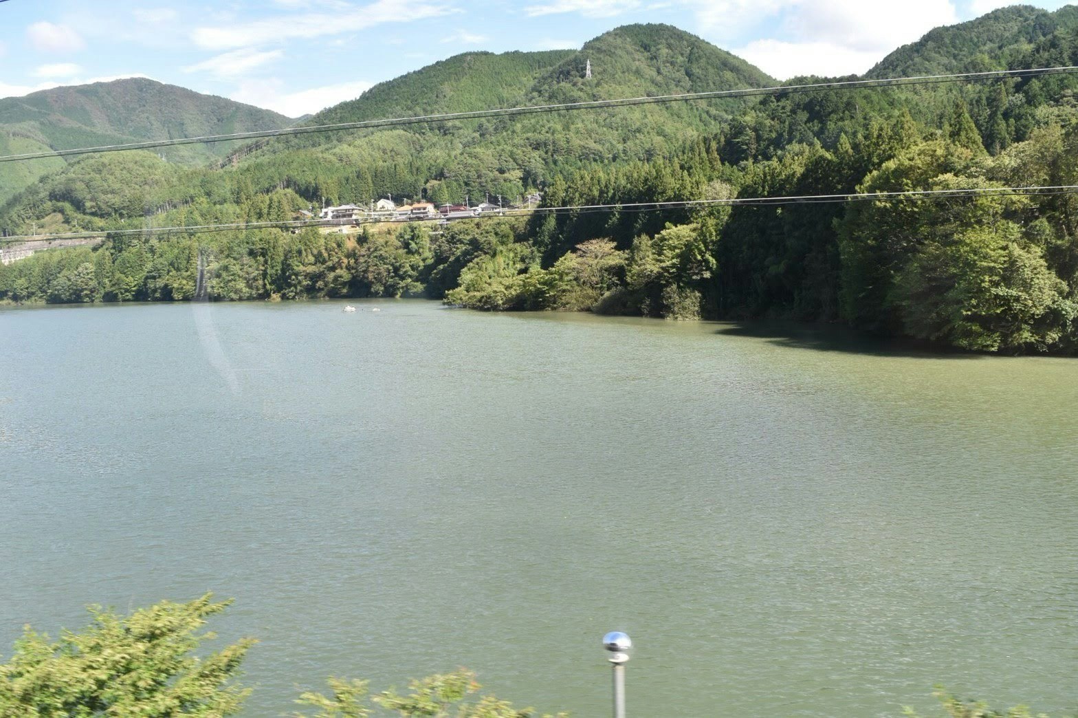 群山與青綠丘陵環繞的寧靜湖面