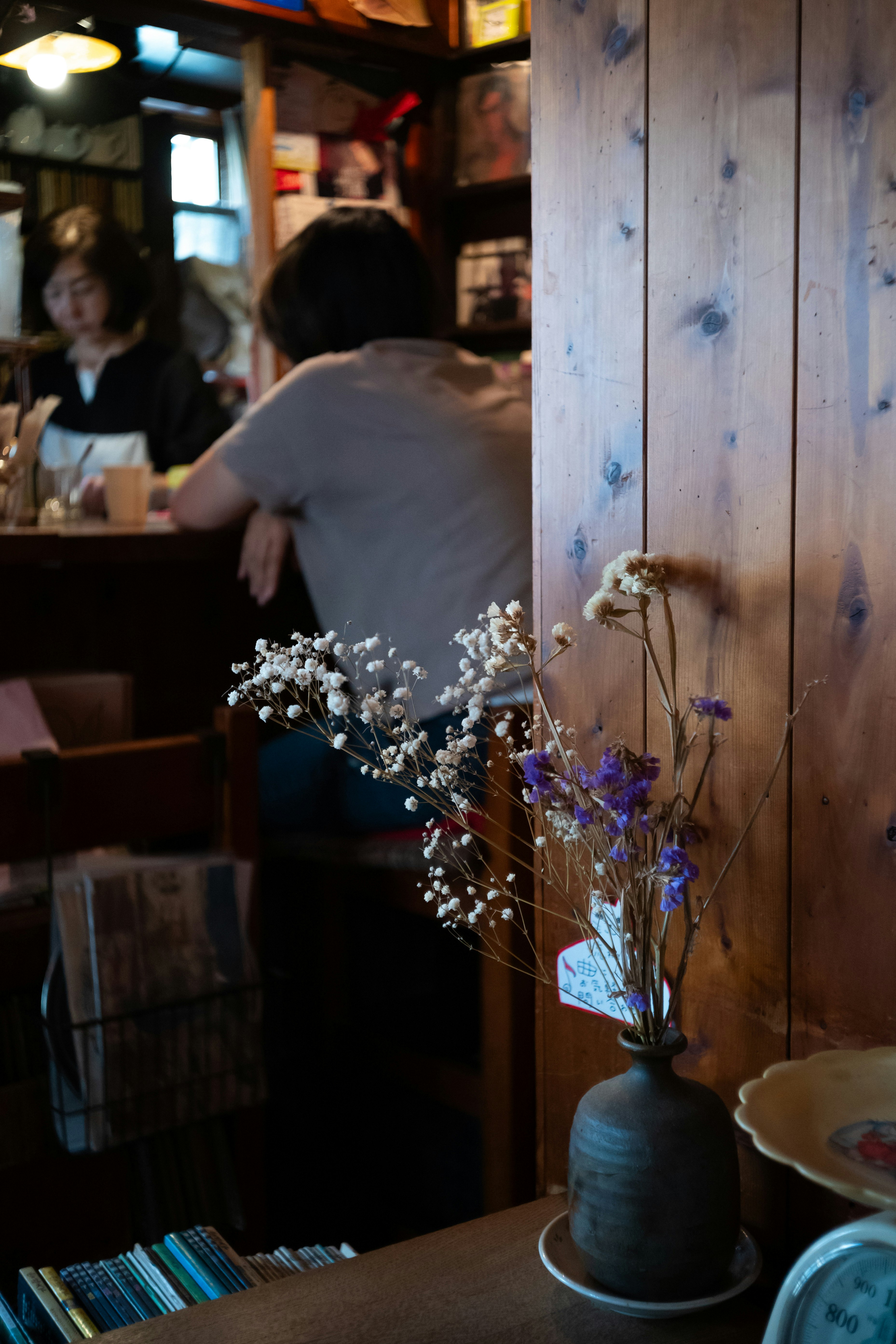 木の壁と花瓶のあるカフェ店内の夕景