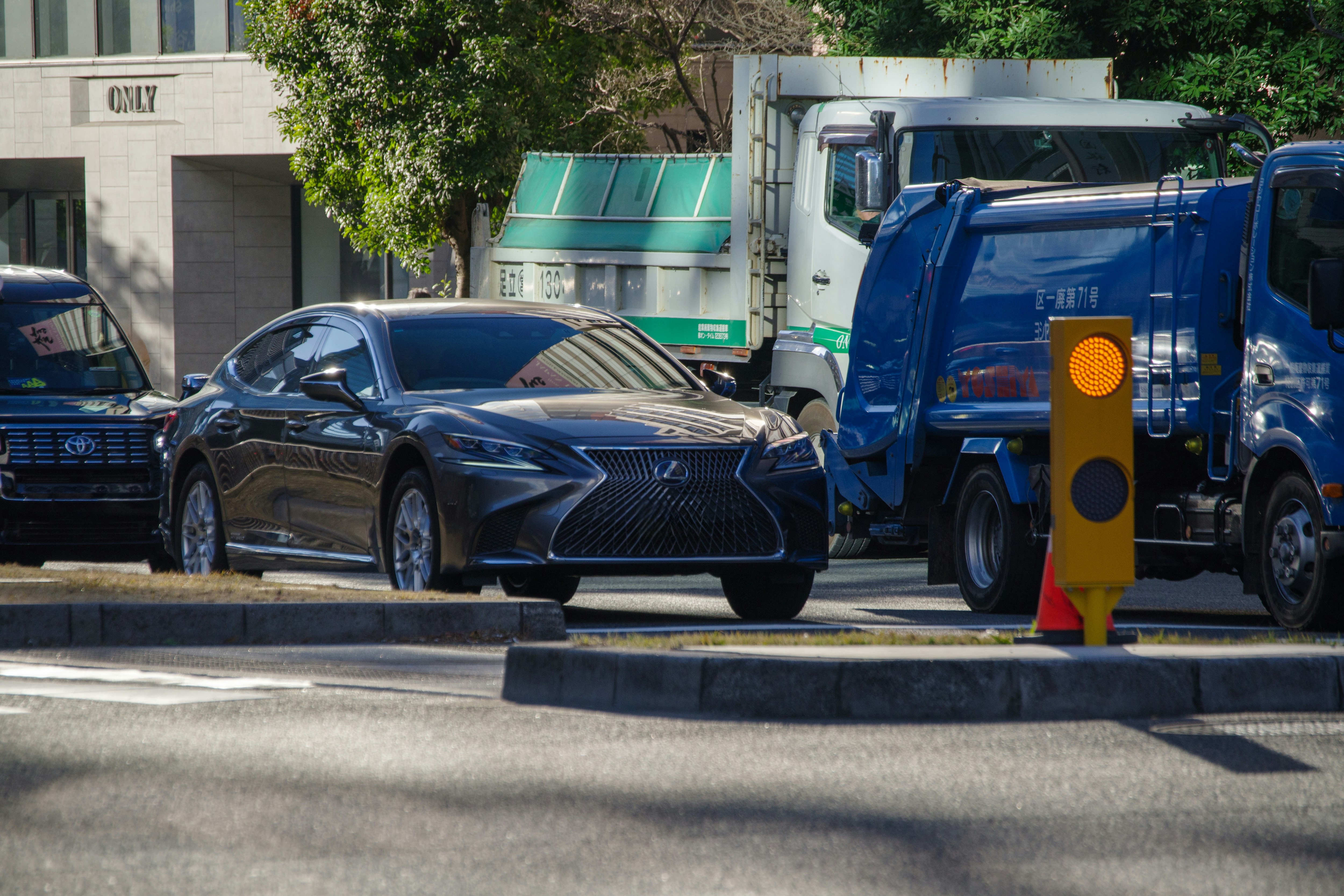 Luxury car parked on a city street beside a truck