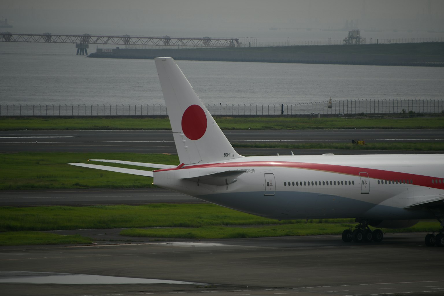 Aile d'un avion Japan Airlines avec logo rouge sur la piste