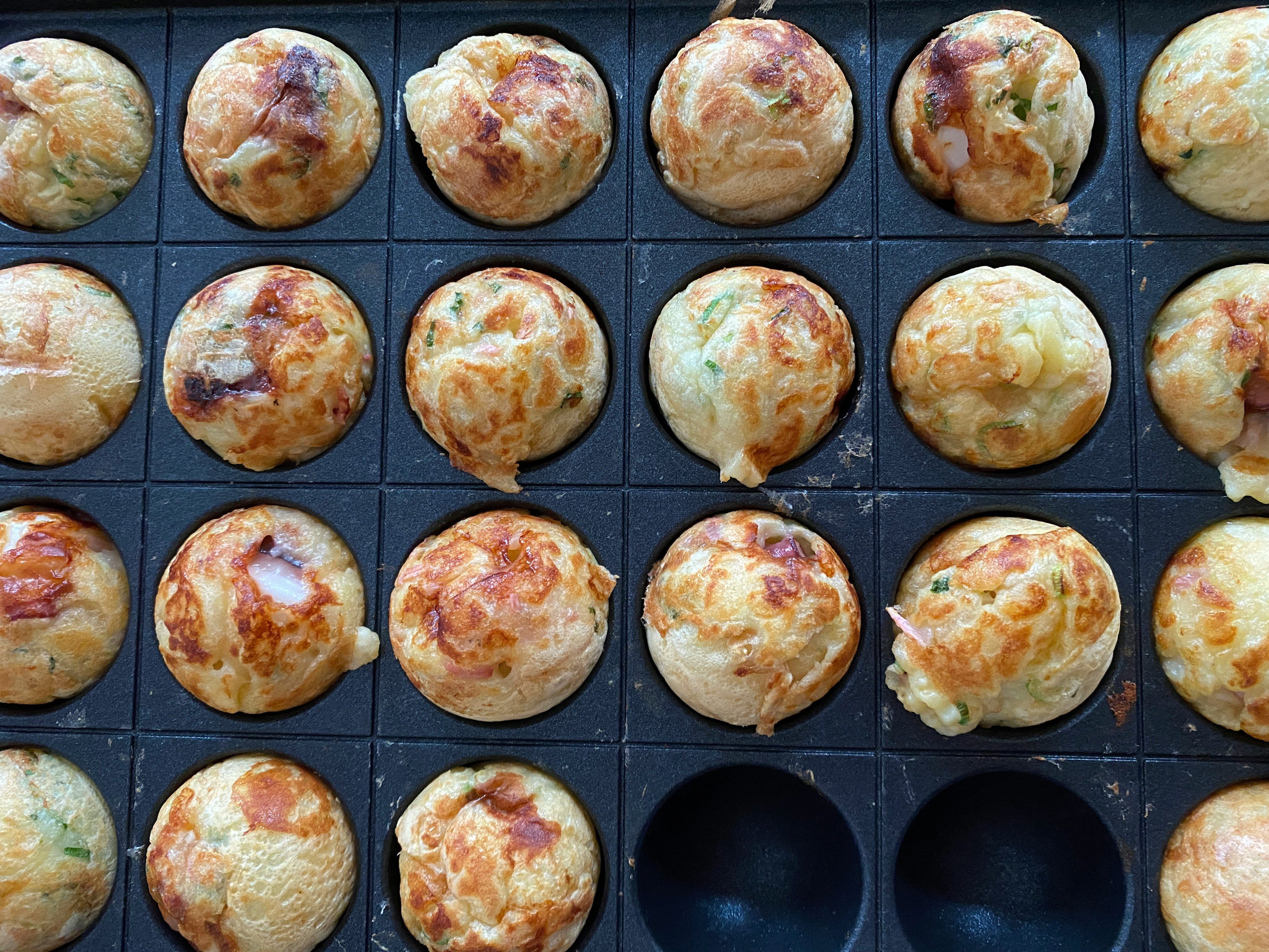 焼きたての丸いパンが並ぶベーカリーのトレイ