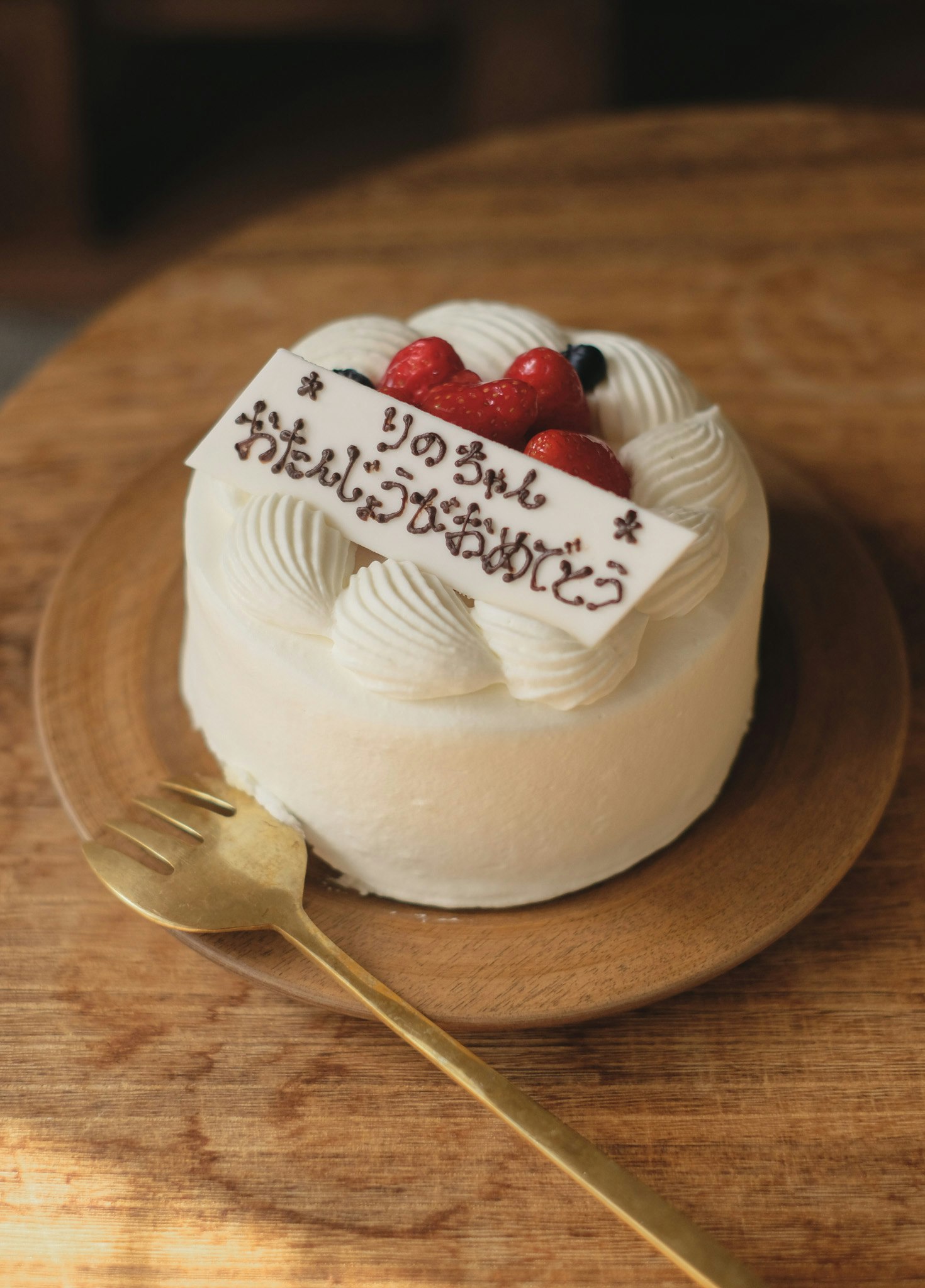 木のテーブルにのった苺のショートケーキ