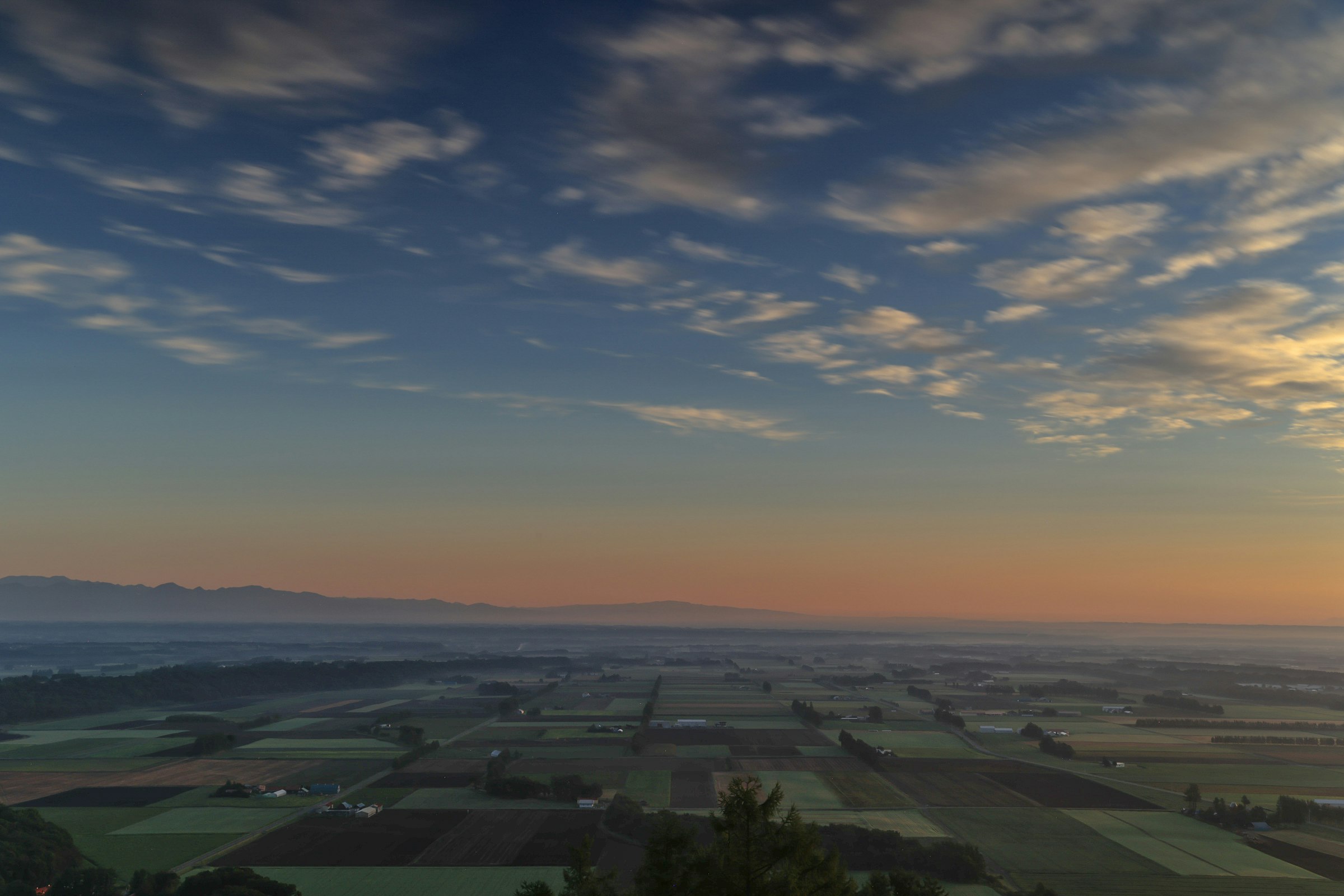 sunset sky over expansive farmland landscape