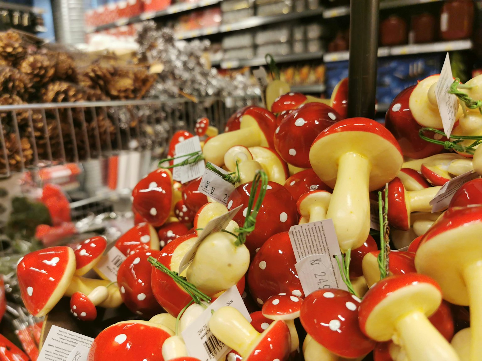 Decorazioni di funghi rossi colorati esposte in un angolo di negozio