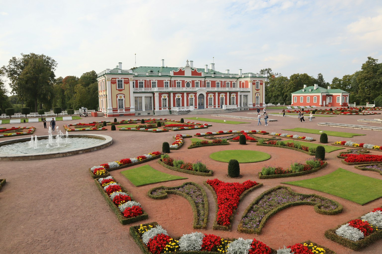 Un giardino bellissimo con aiuole ornate e un grande edificio sullo sfondo