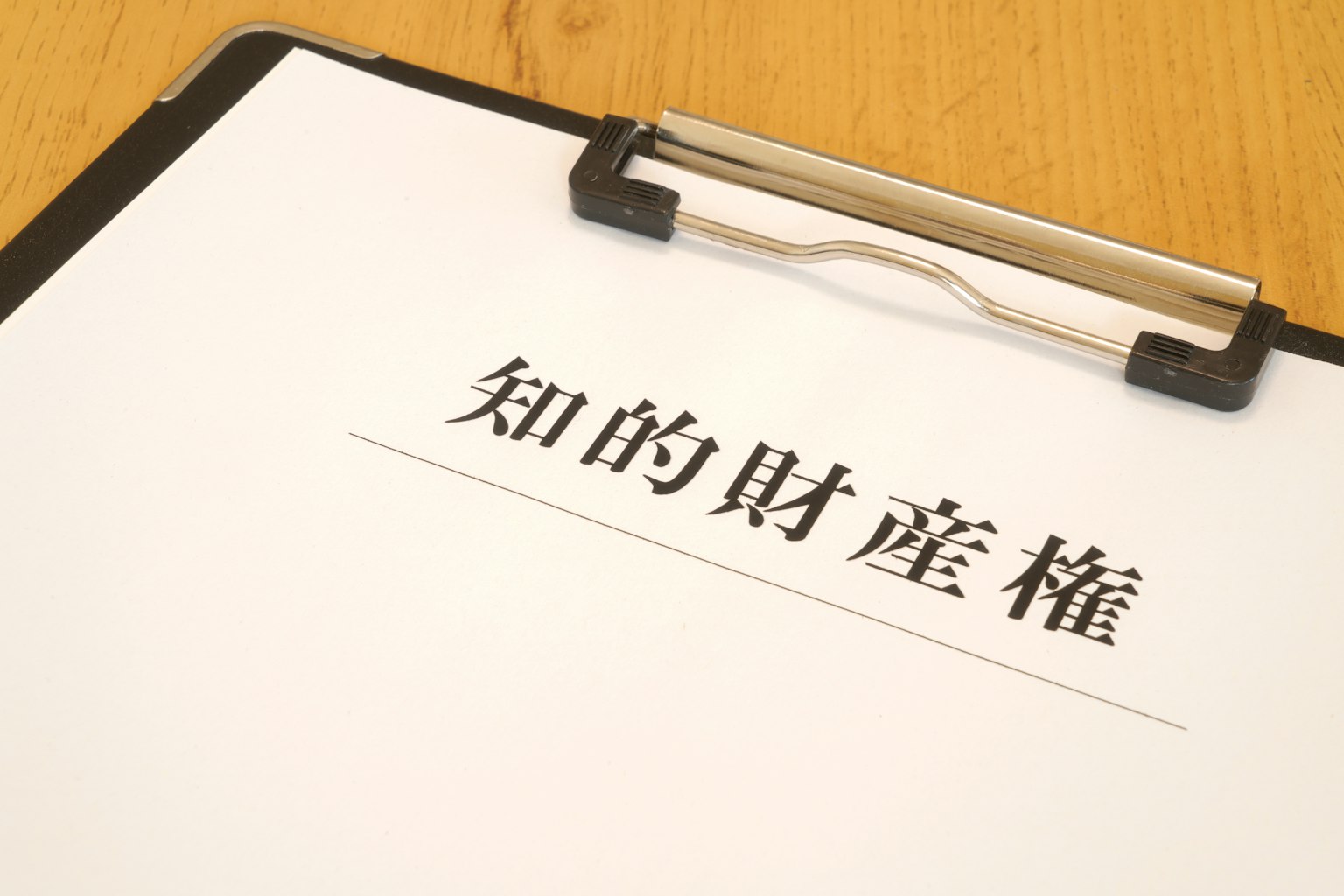 Một bảng kẹp với một tờ giấy trắng có nội dung quyền sở hữu trí tuệ