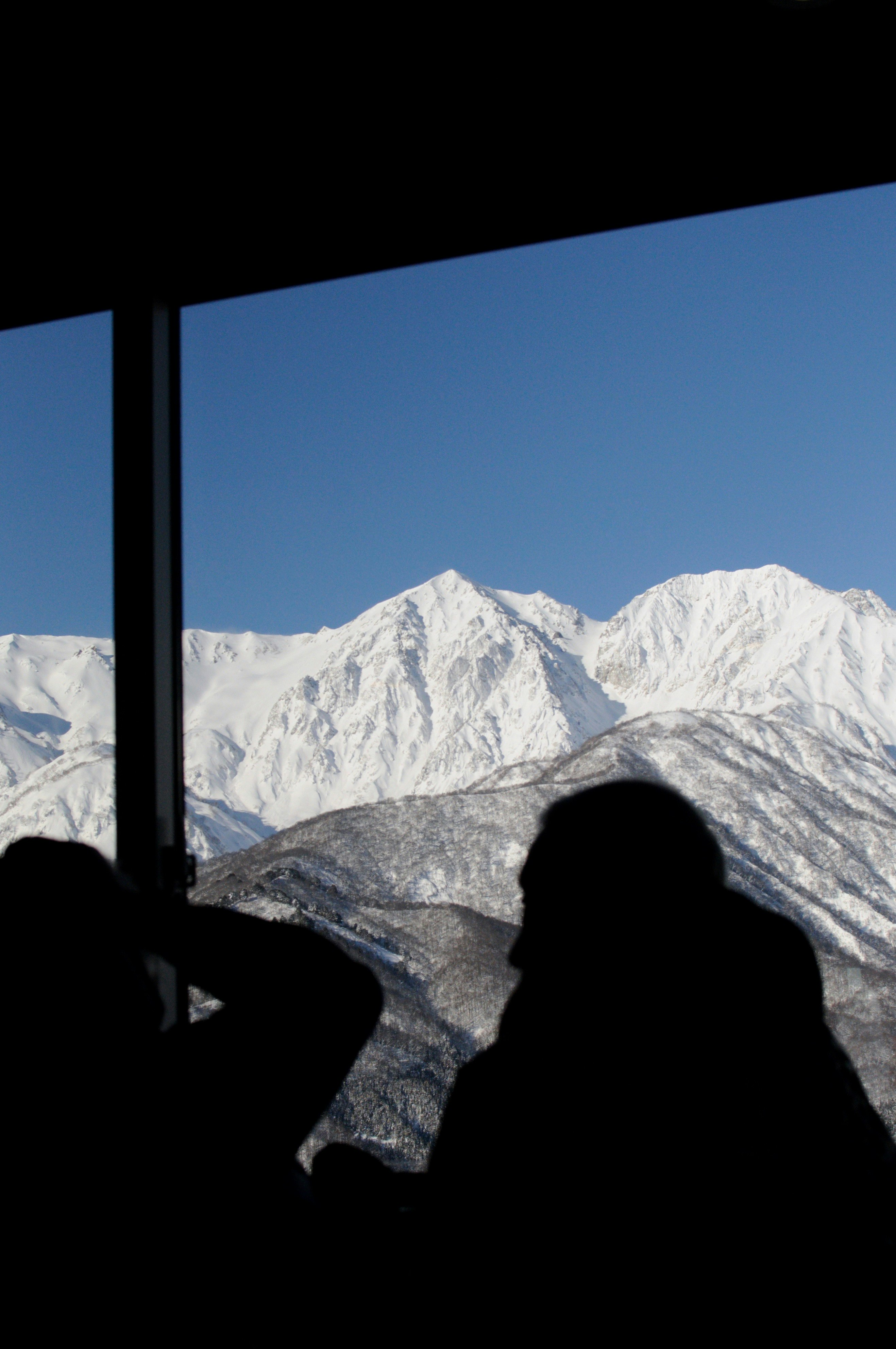 Pause café près d’une fenêtre donnant sur des crêtes montagneuses