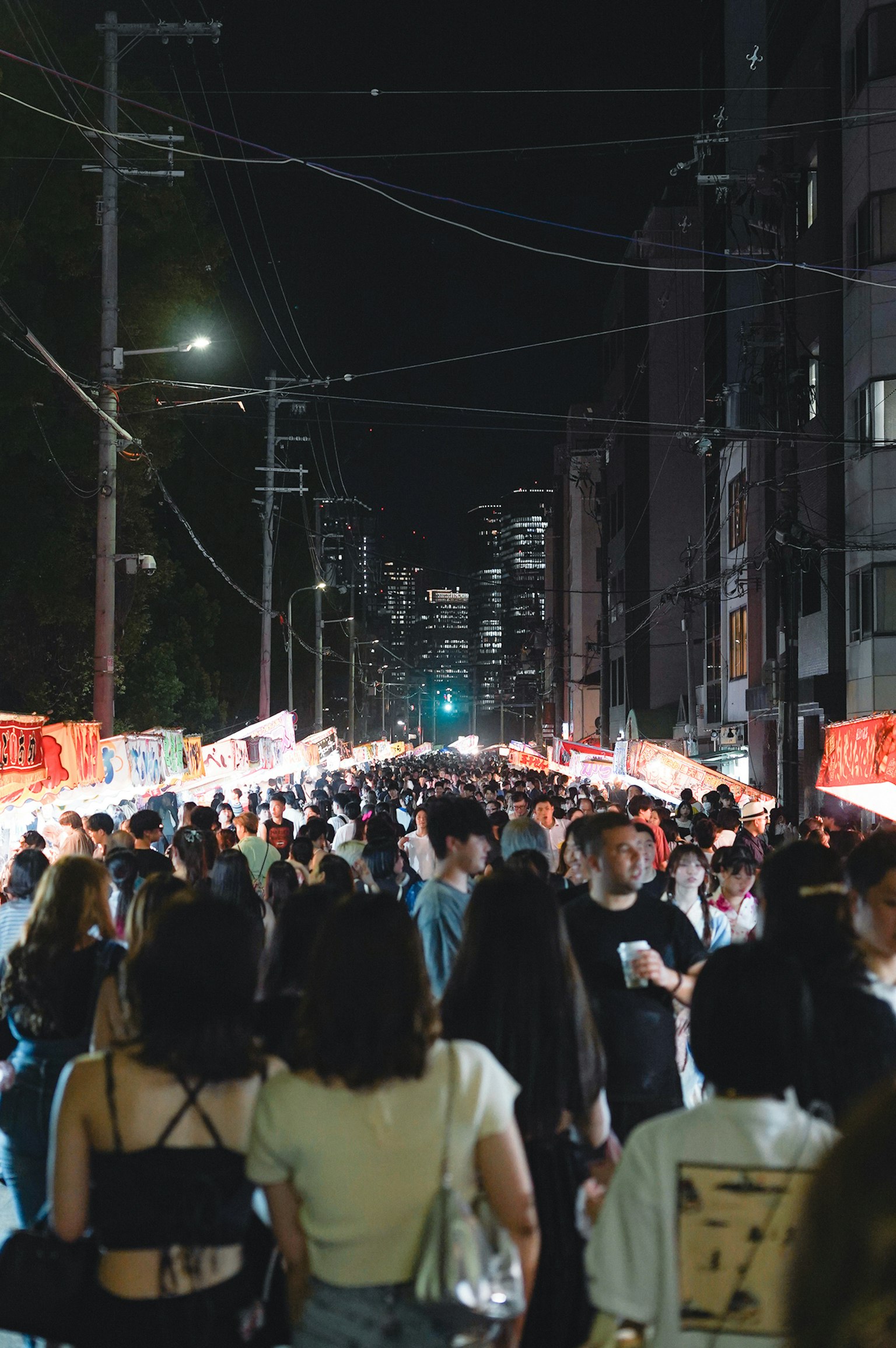 夜の街並みで賑わう人々と屋台の光