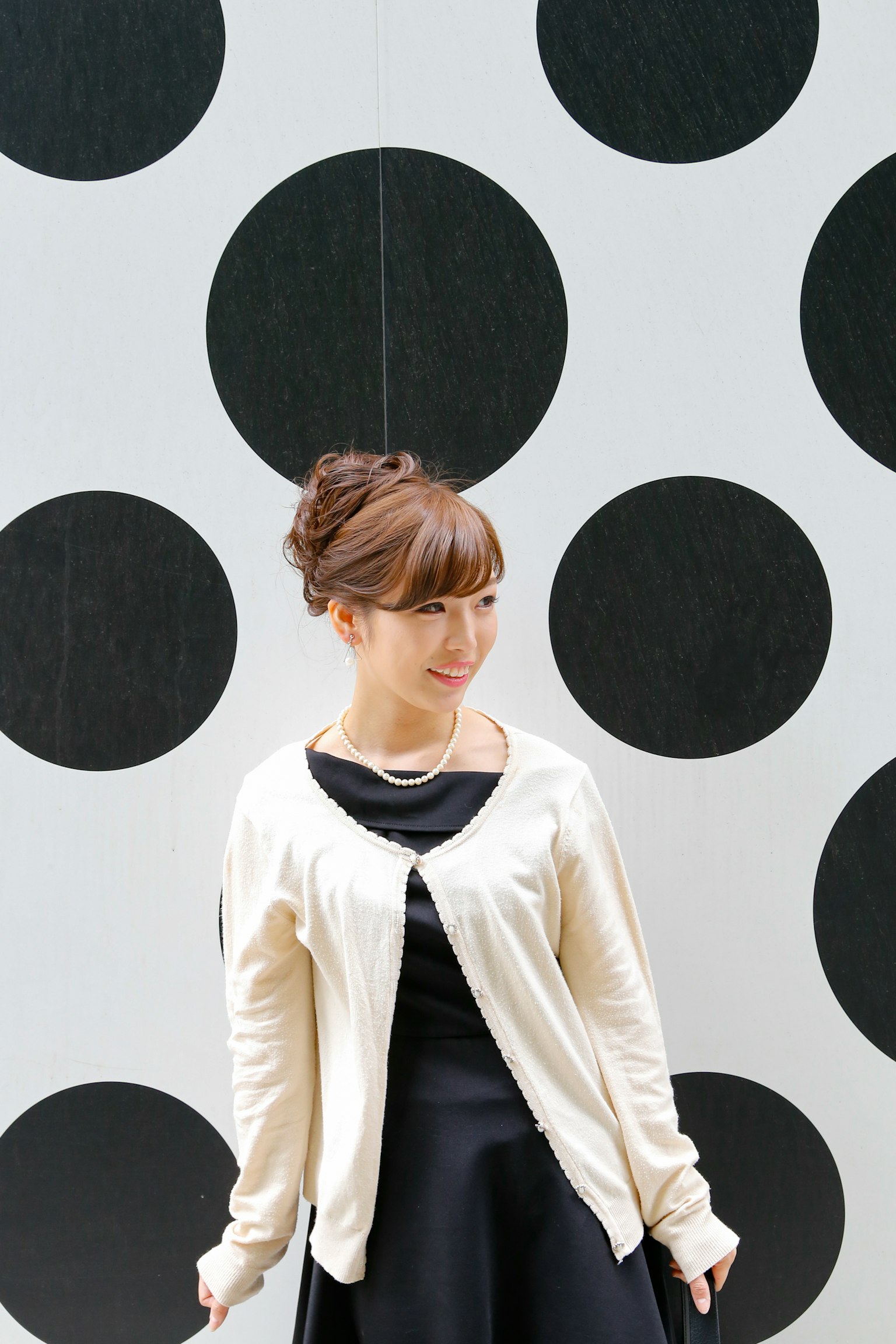 ภาพพอร์ตเทรตของหญิงสาวยืนอยู่หน้าผนังที่มีวงกลมสีดำใหญ่