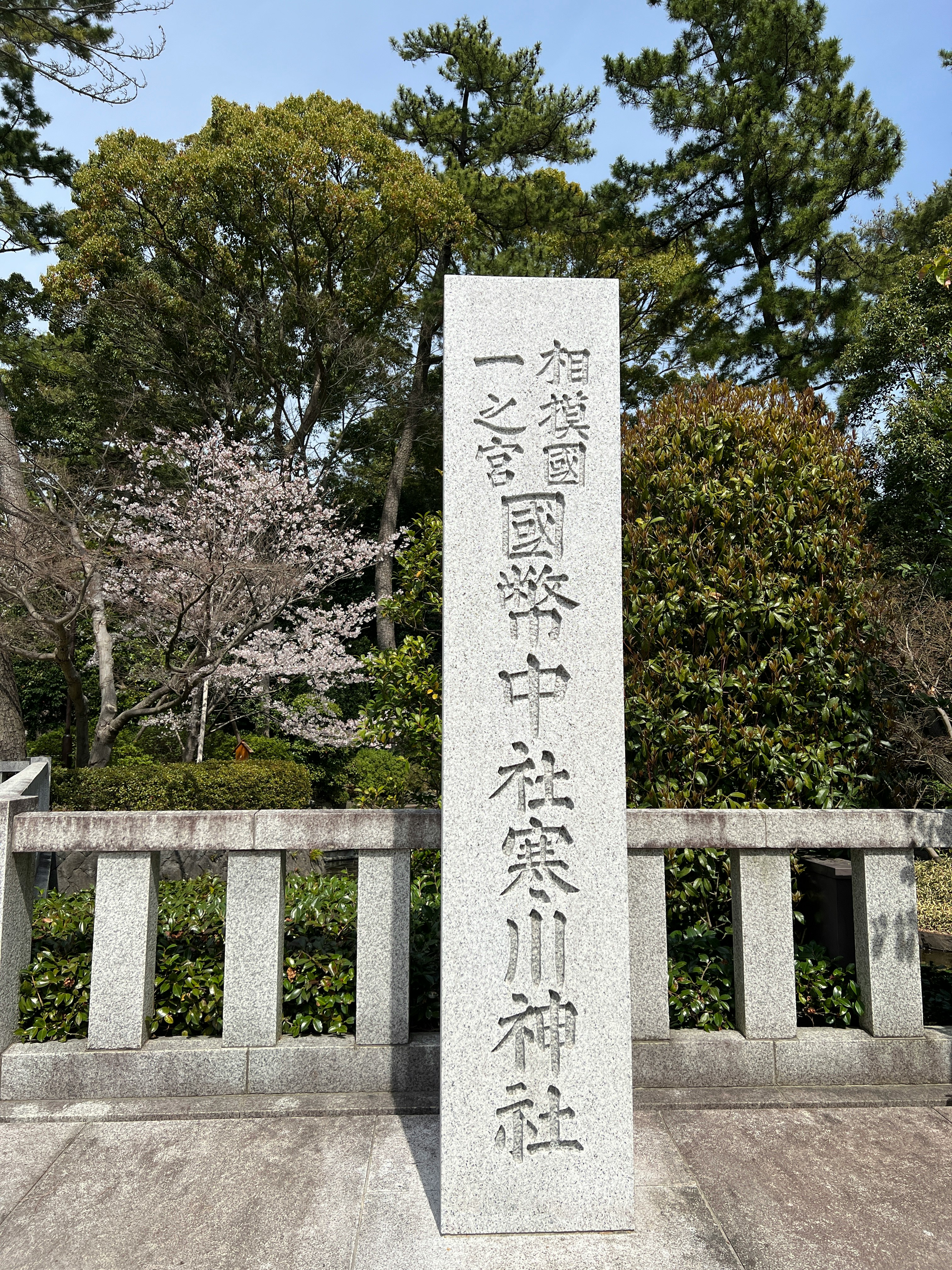 桜の庭園に立つ石柵と「福聚國家中祈願所」碑のある参拝スポット