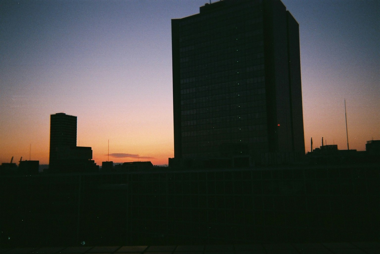 Silhouette der Stadt gegen einen lebhaften Sonnenuntergang