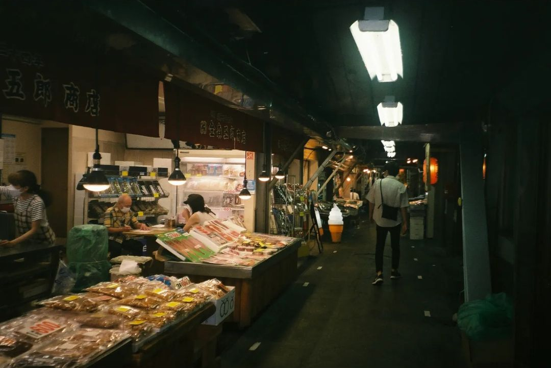 夜晚小巷里摆满熟食与食材的店铺门口