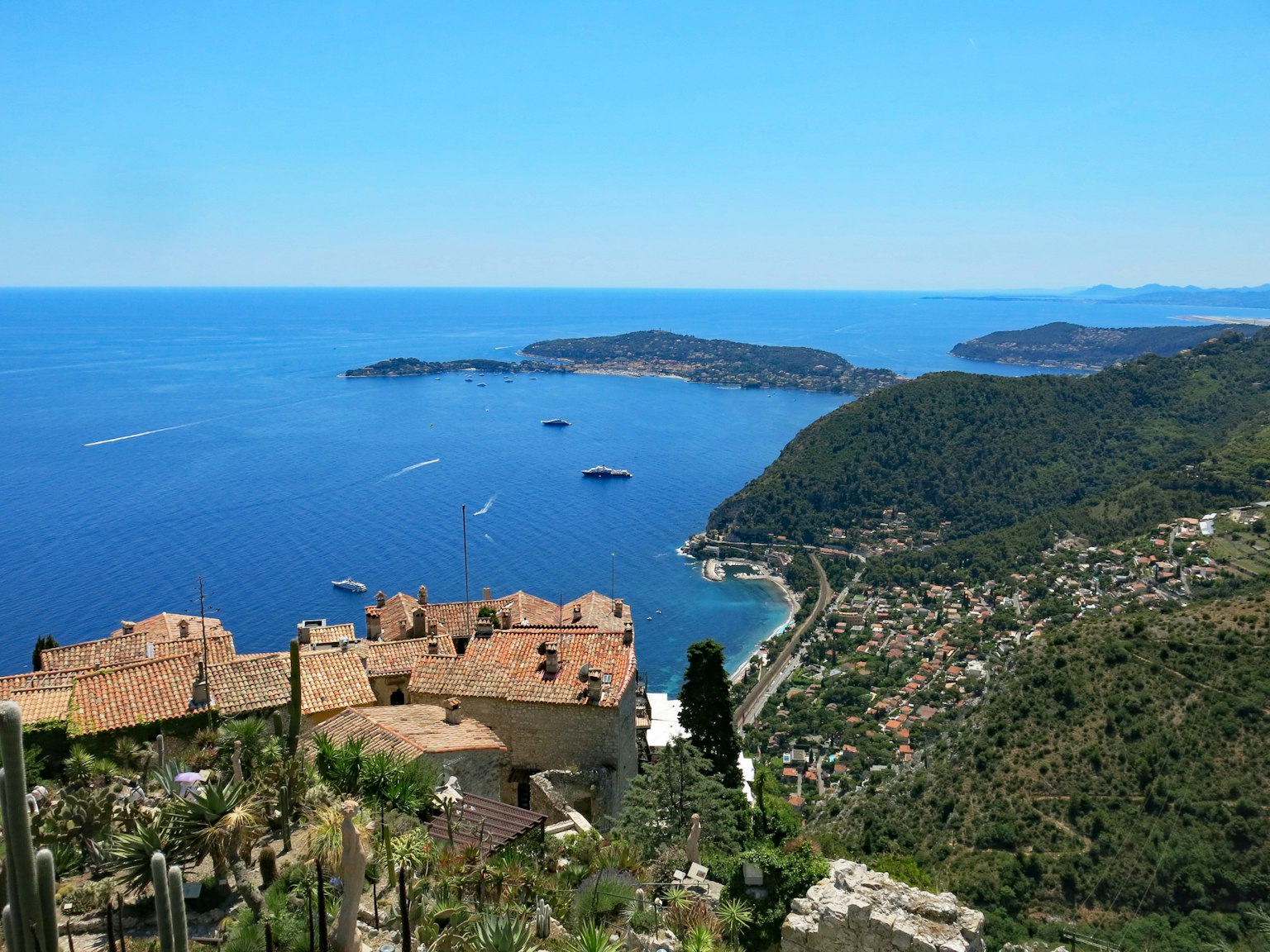 Stunning coastal view featuring clear blue sea and lush green hills