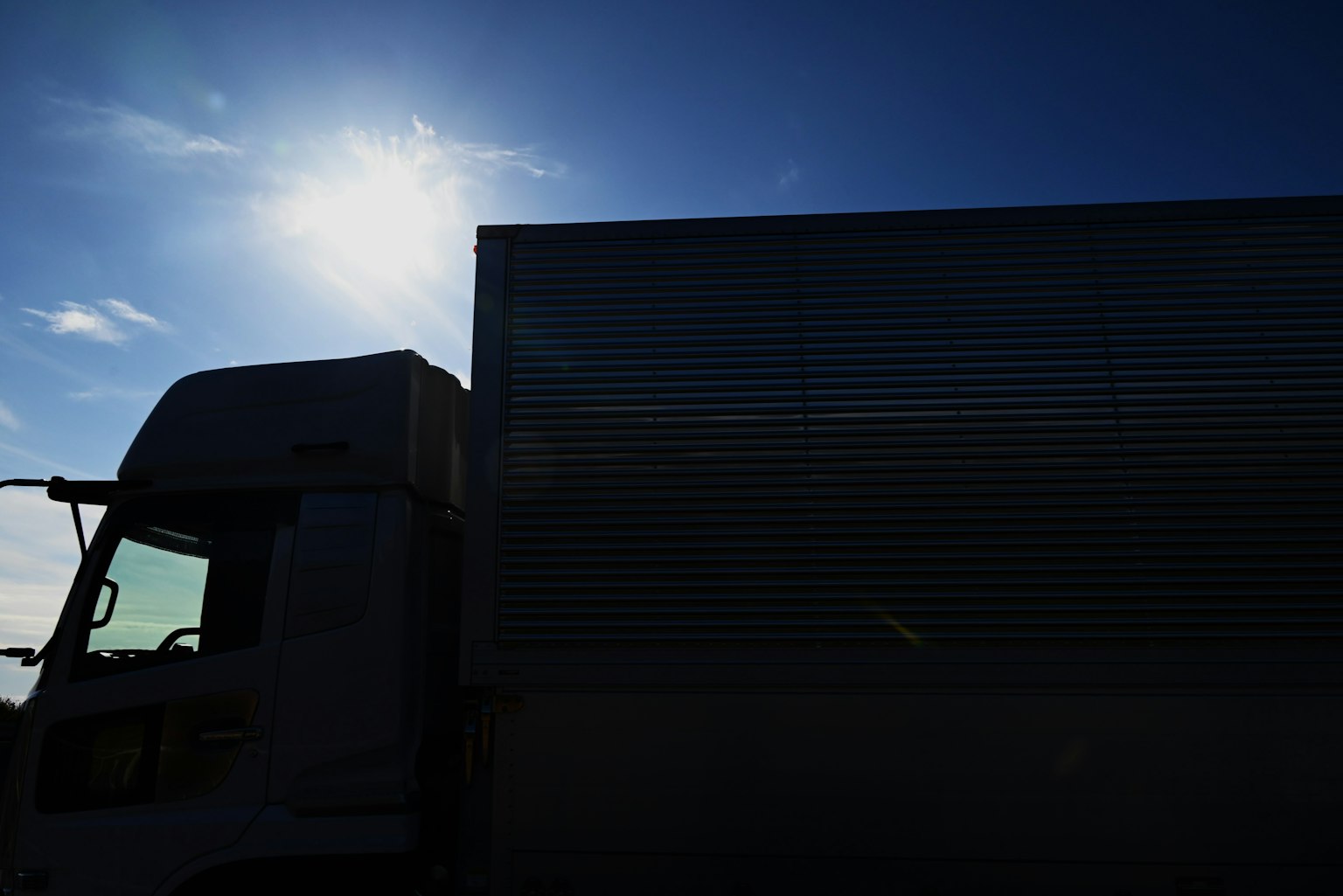 Silhouette eines Lastwagens vor blauem Himmel