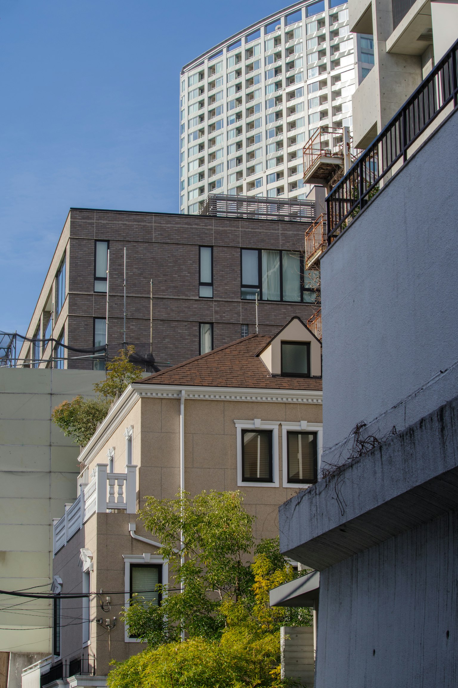 近代的な高層ビルと歴史的な家屋が共存する都市の風景