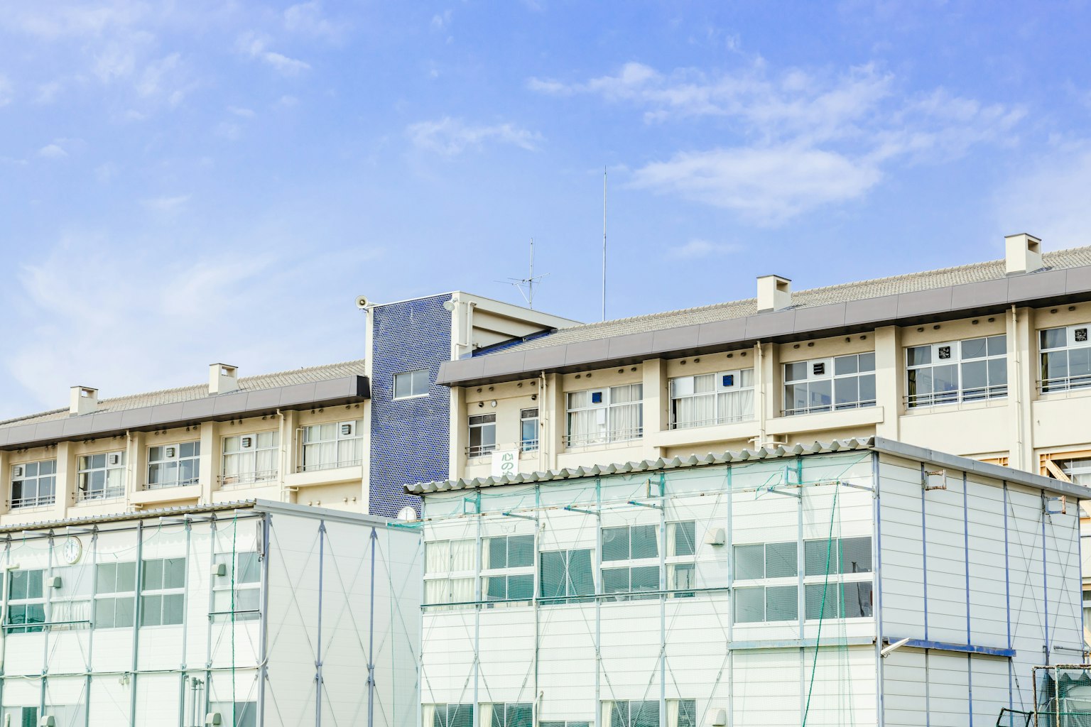 Außenansicht eines modernen Gebäudes mit Glasfassade unter einem blauen Himmel