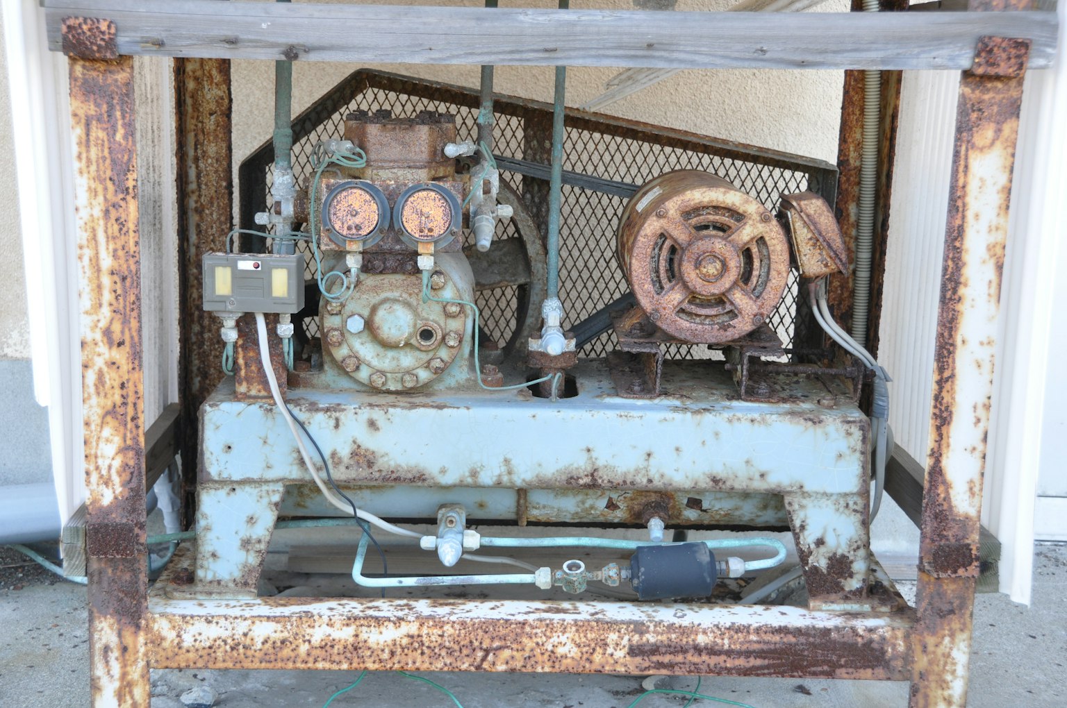 Vieja máquina compresora oxidada con piezas mecánicas