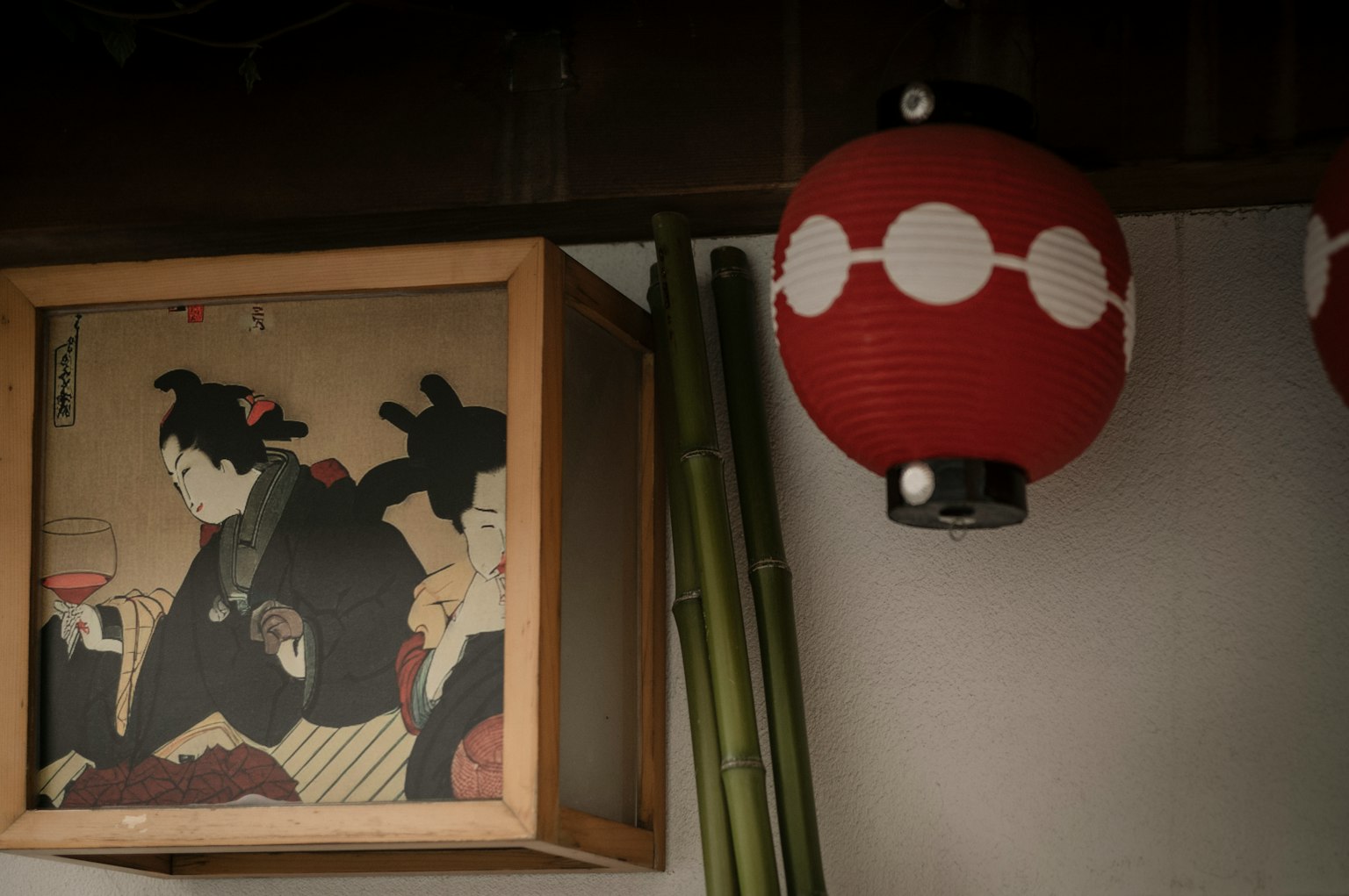 赤い提灯と竹の背景に浮世絵のフレームがある日本の伝統的なインテリア