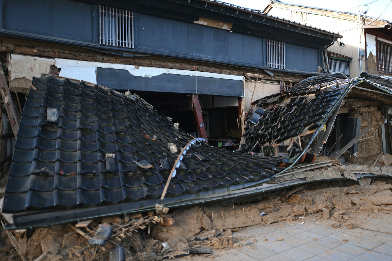 Eingestürztes Dach eines traditionellen japanischen Hauses durch Erdbebenschäden