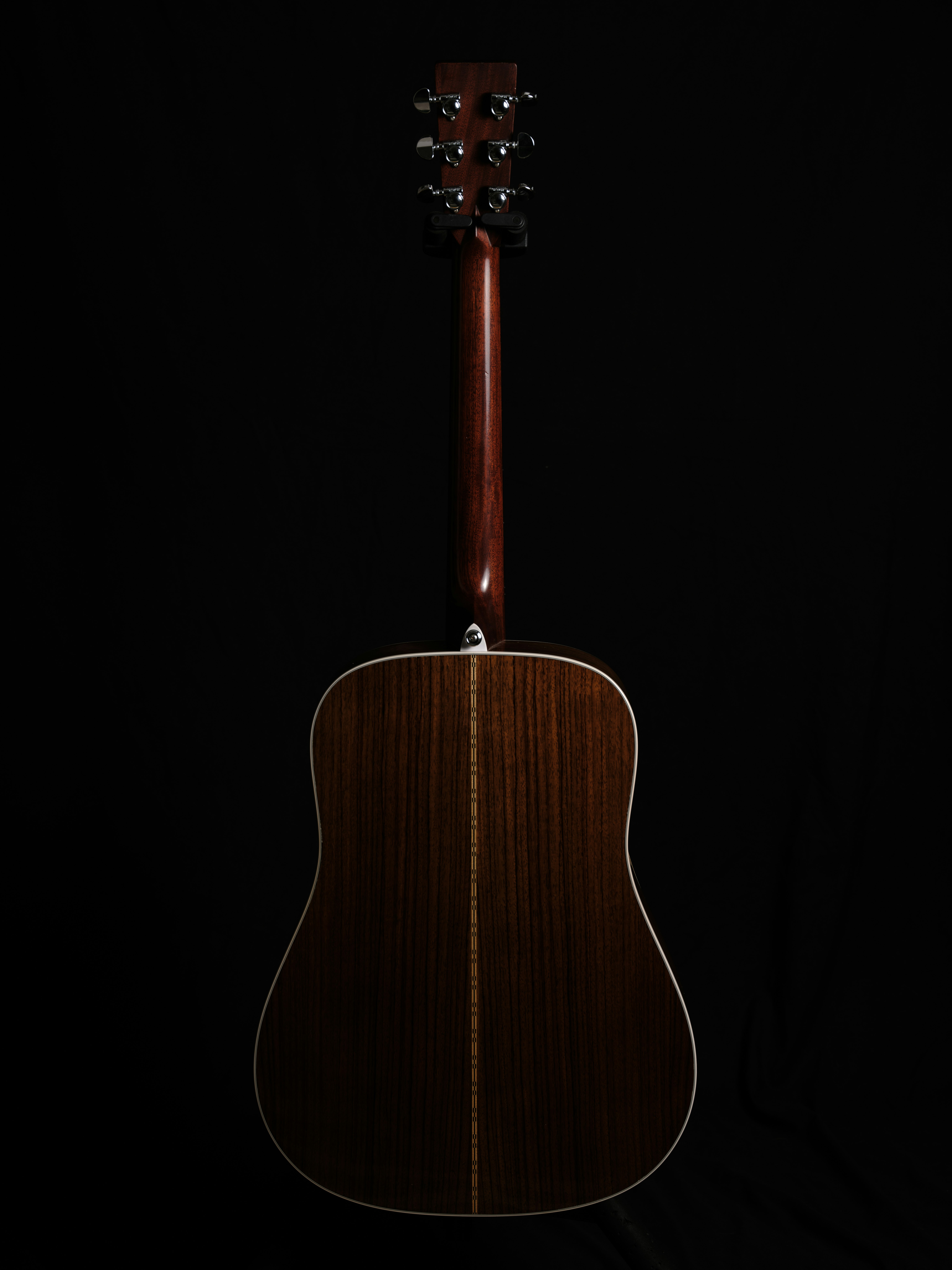 đàn guitar acoustic gỗ treo trên nền đen