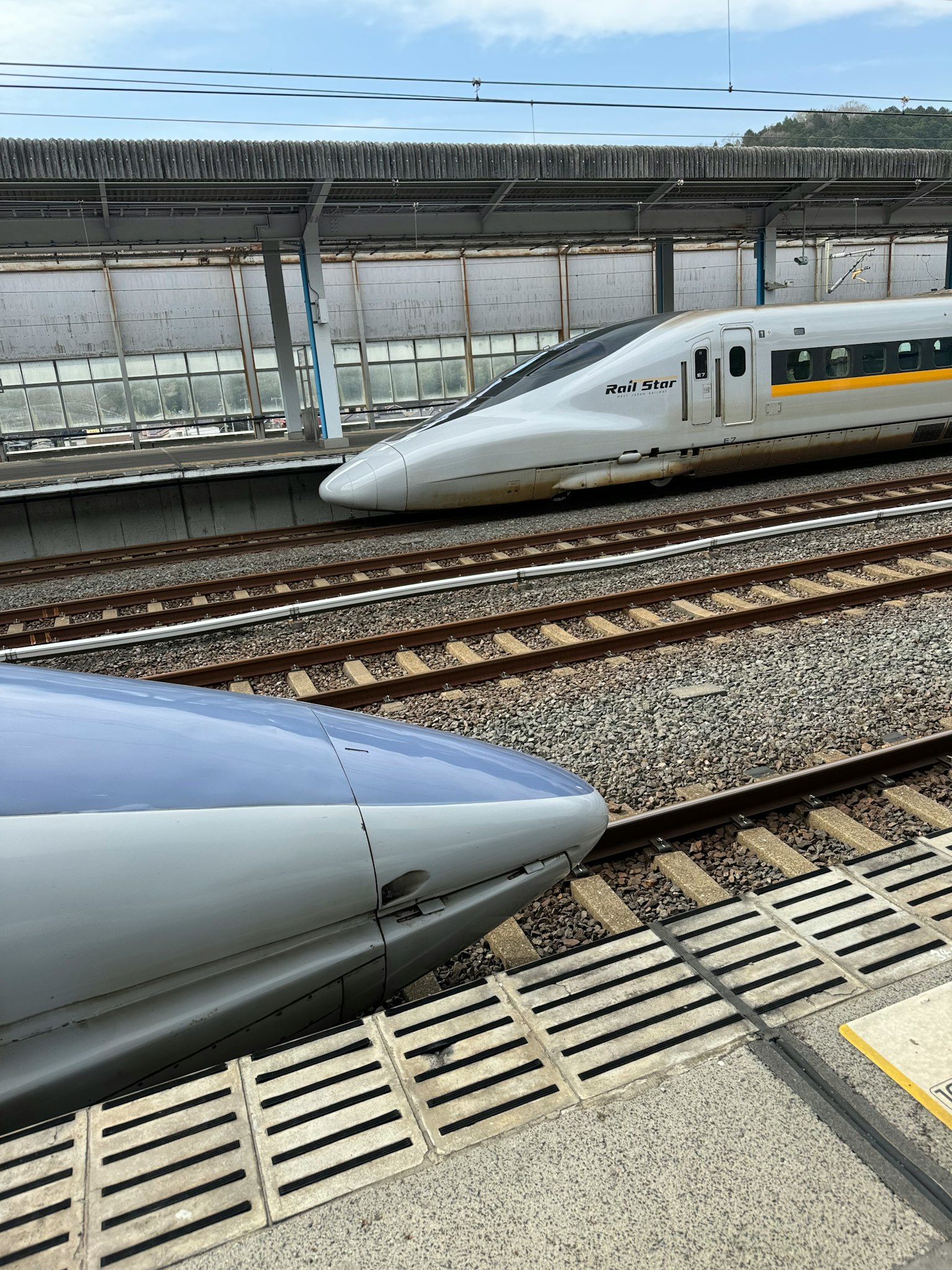 Deux trains Shinkansen à une station montrant leurs designs élégants