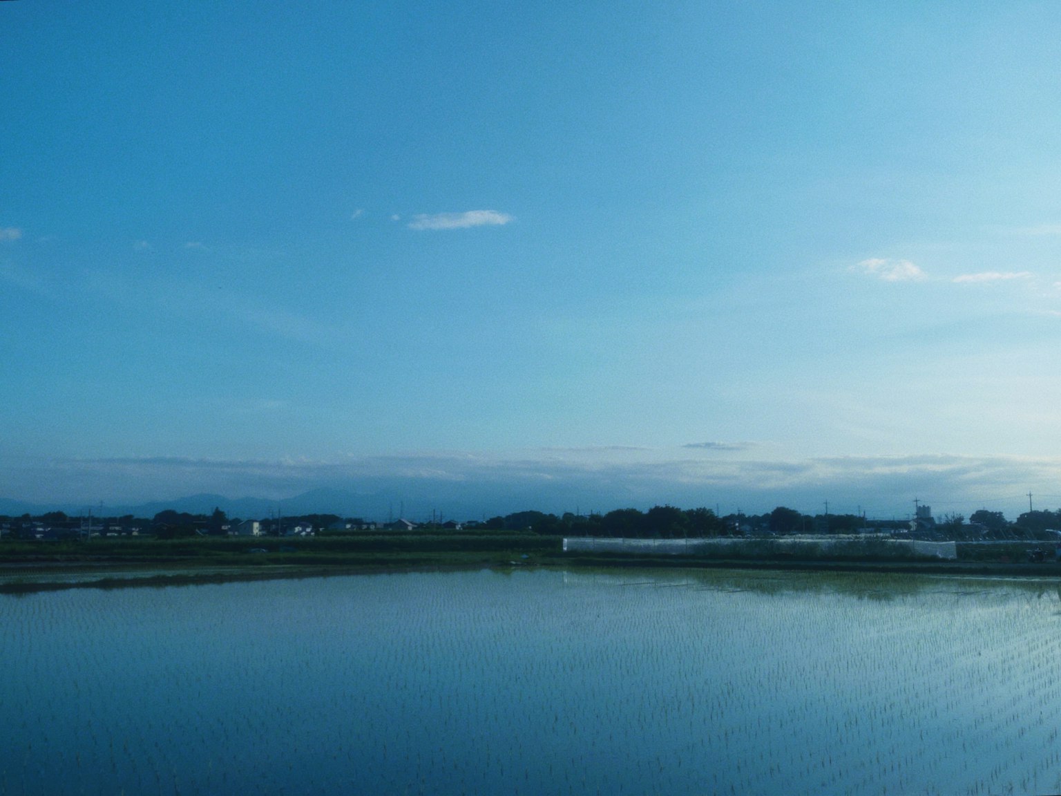 Un paisaje sereno con un cielo azul y una superficie de agua tranquila