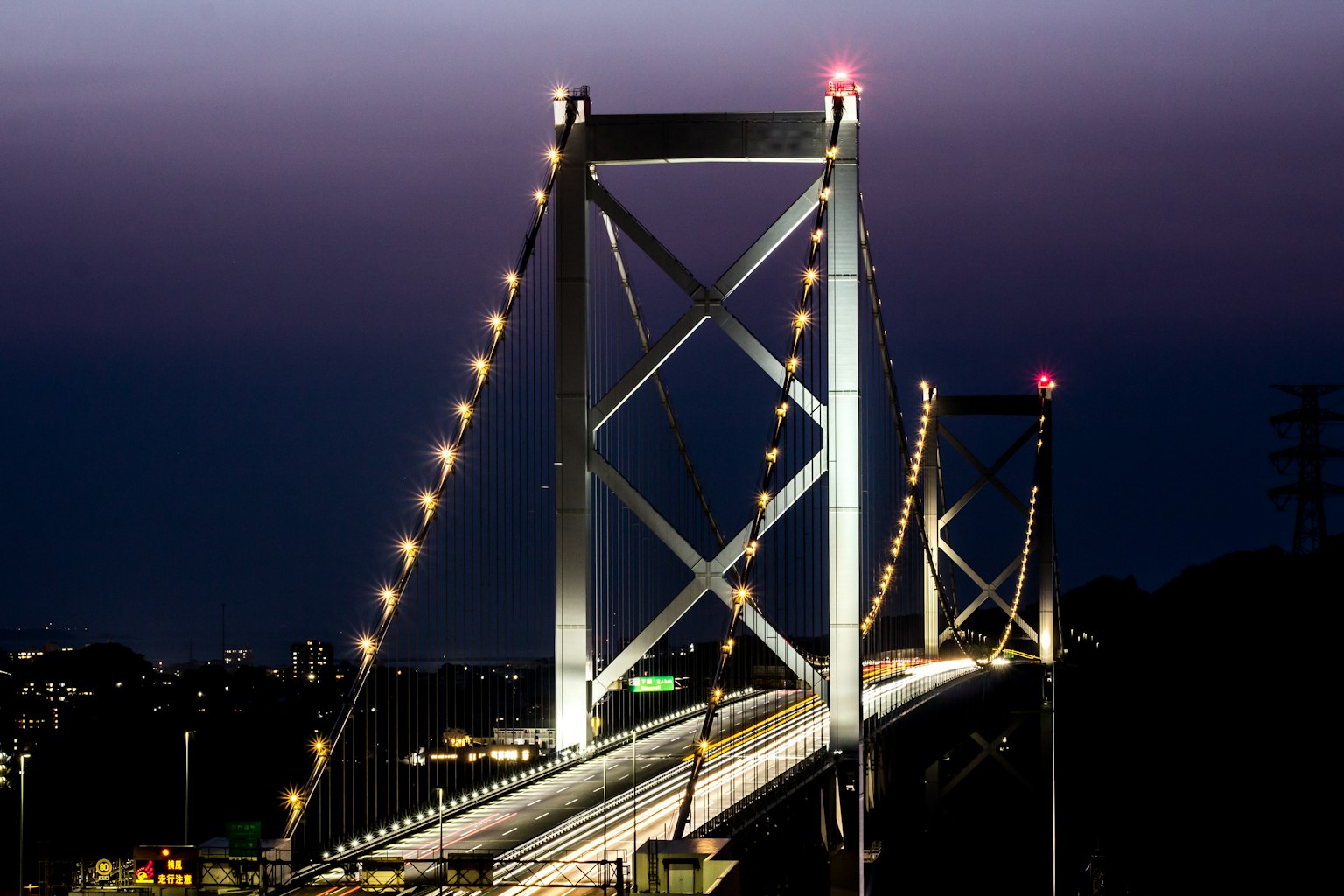 Illuminated suspension bridge against a twilight sky