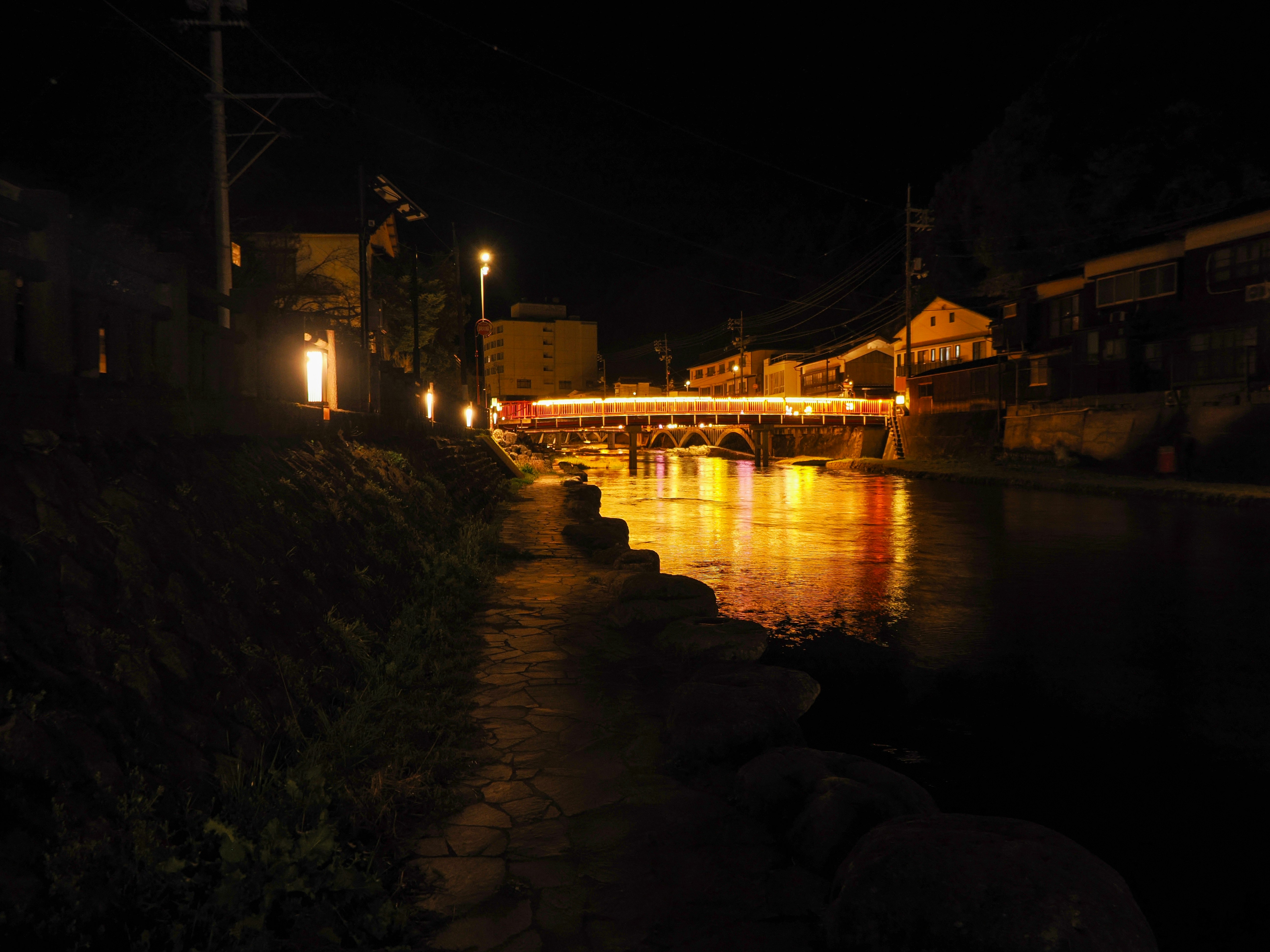 passeggiata sul lungofiume con pavimentazione in pietra e lampioni di notte