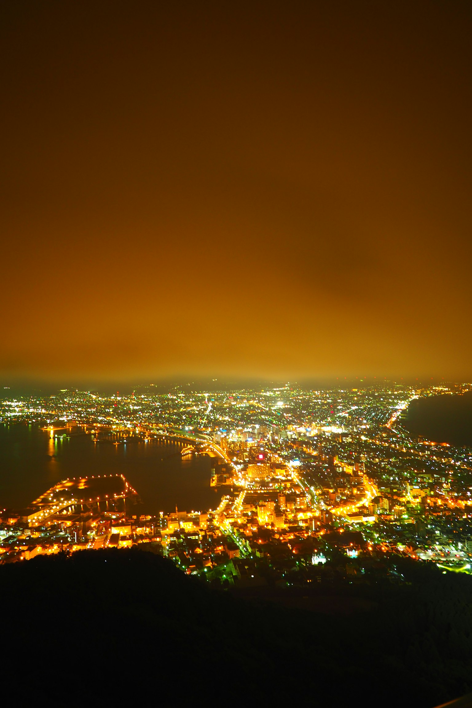 Una hermosa vista nocturna de una ciudad y un puerto iluminados
