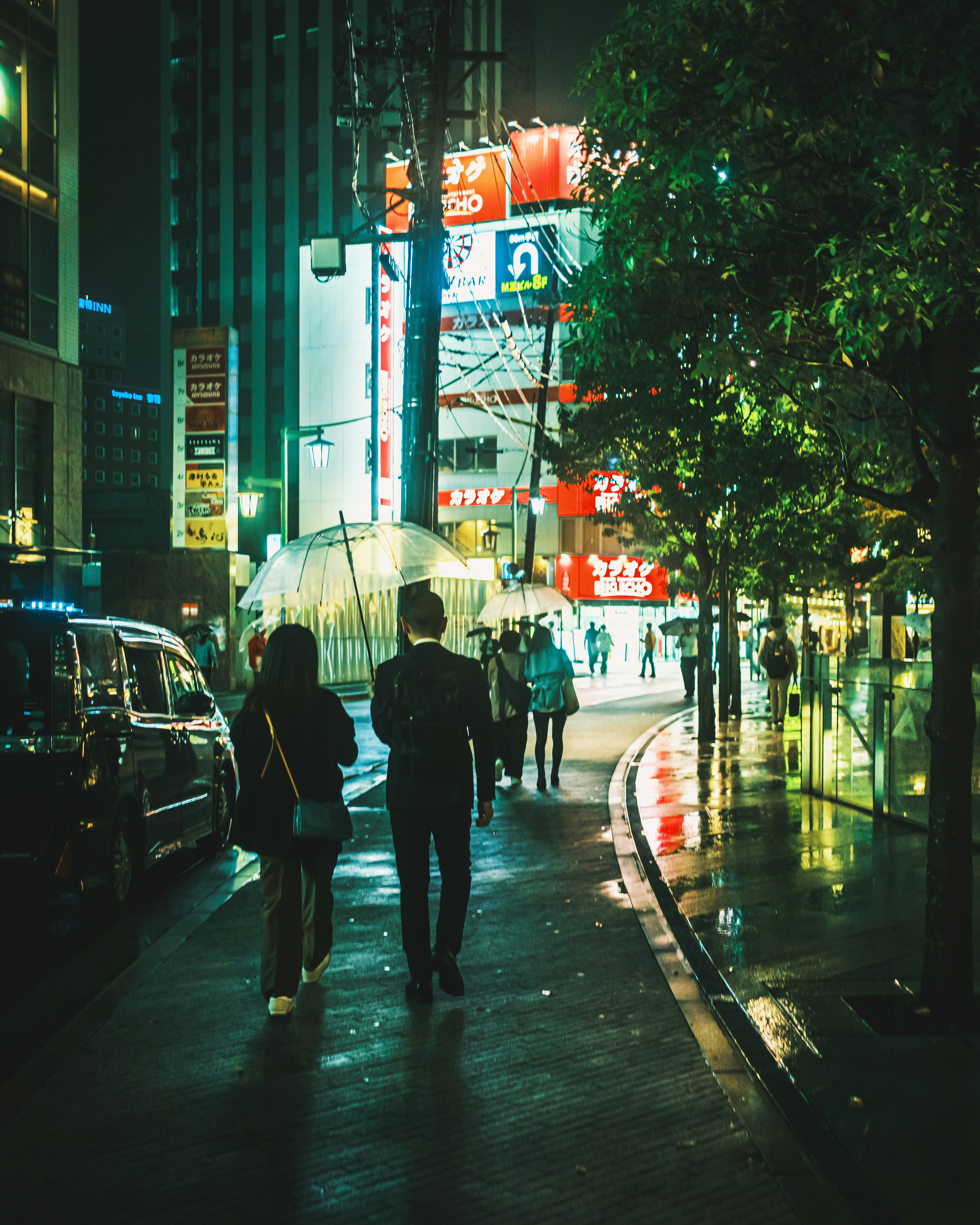 雨上がりの名古屋の歓楽街を歩く人々の夜景の街路