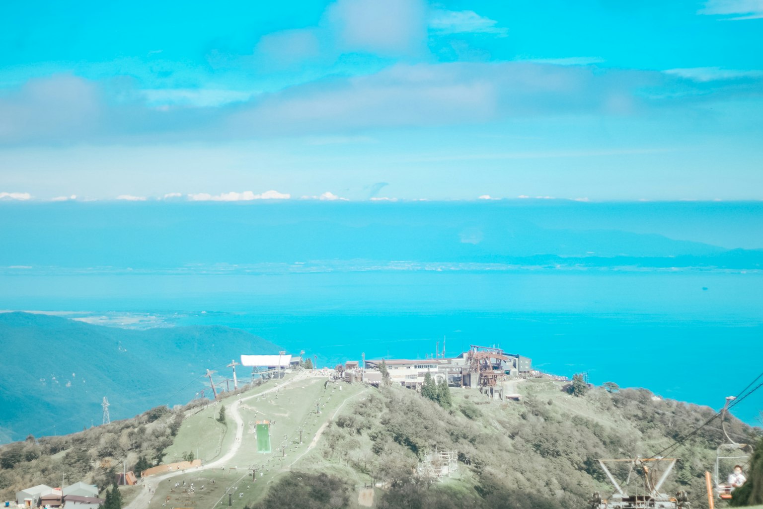 蓝色海洋和山丘的风景在晴朗的天空下