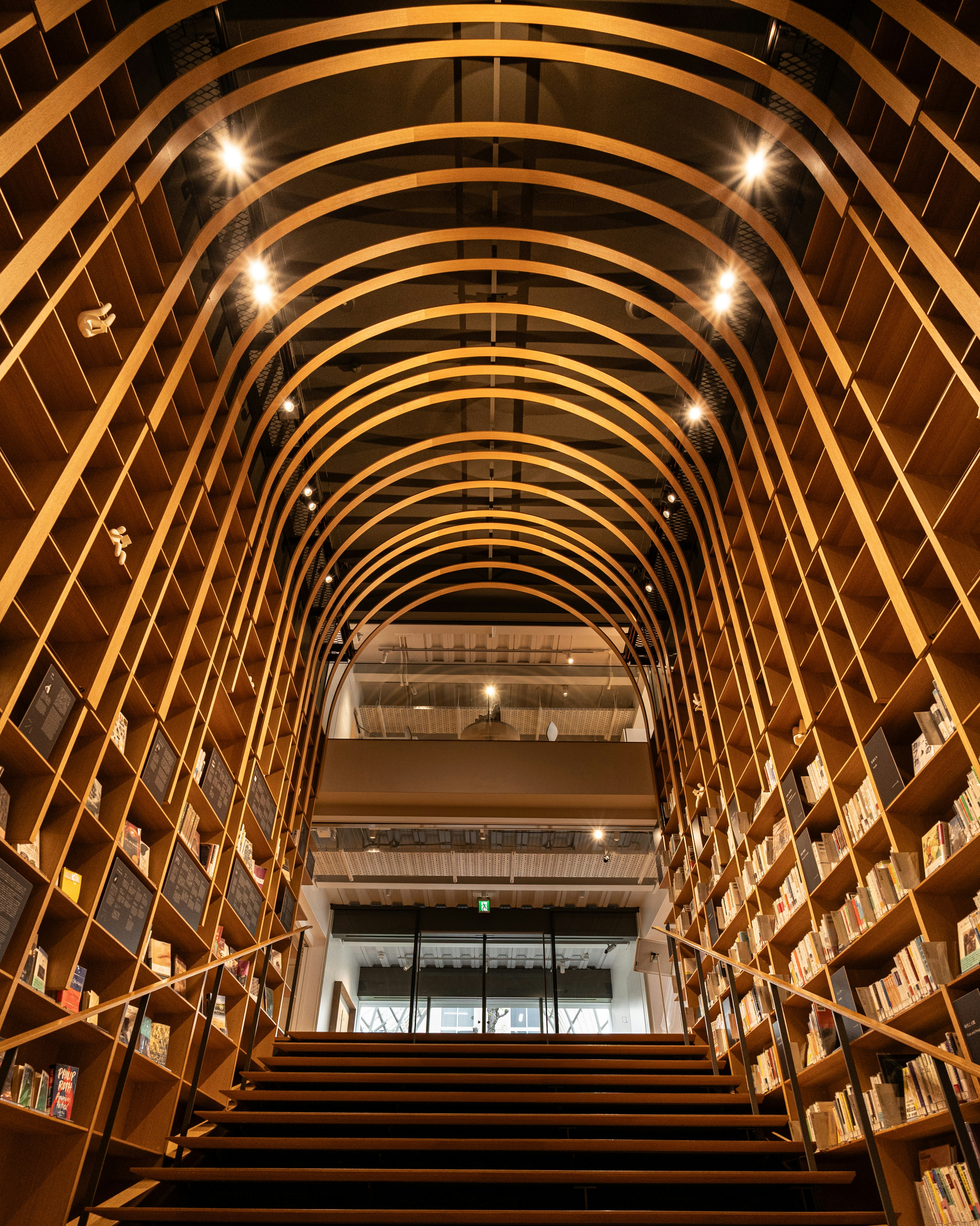 interior space with an arched bookshelf and staircase