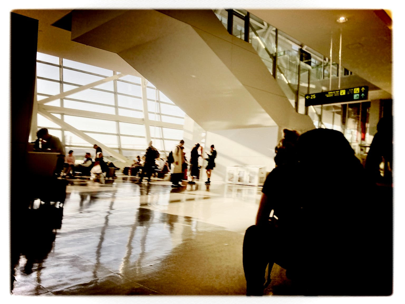 明るい空間に人々が待機している空港の内部の様子