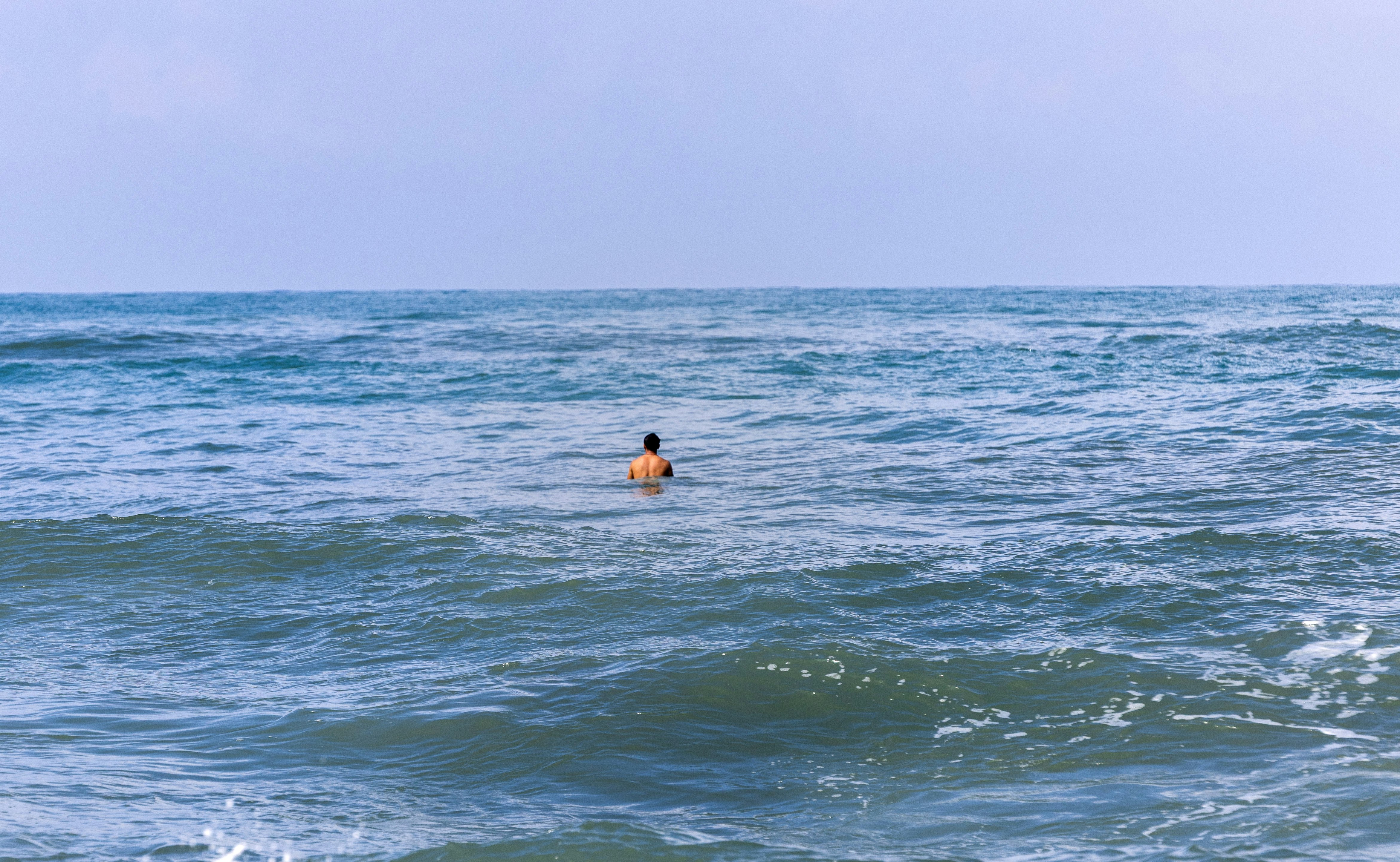波間に浮かぶ一人のサーファーのいる海の風景