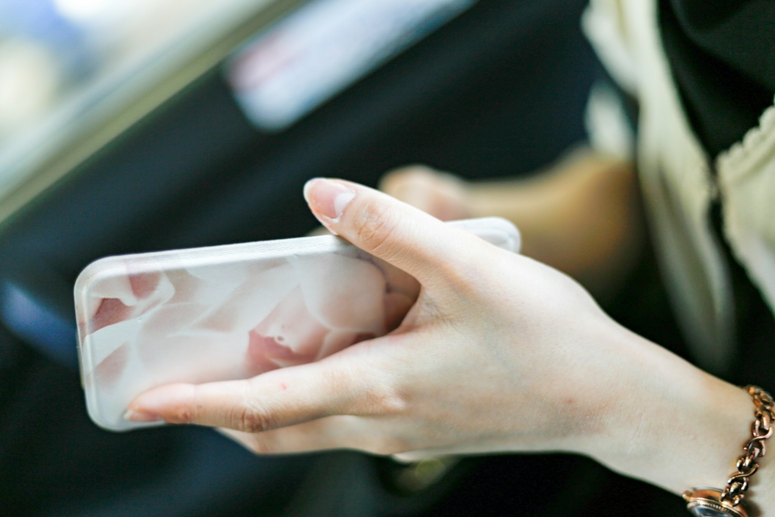 A woman's hand holding a smartphone with a transparent case