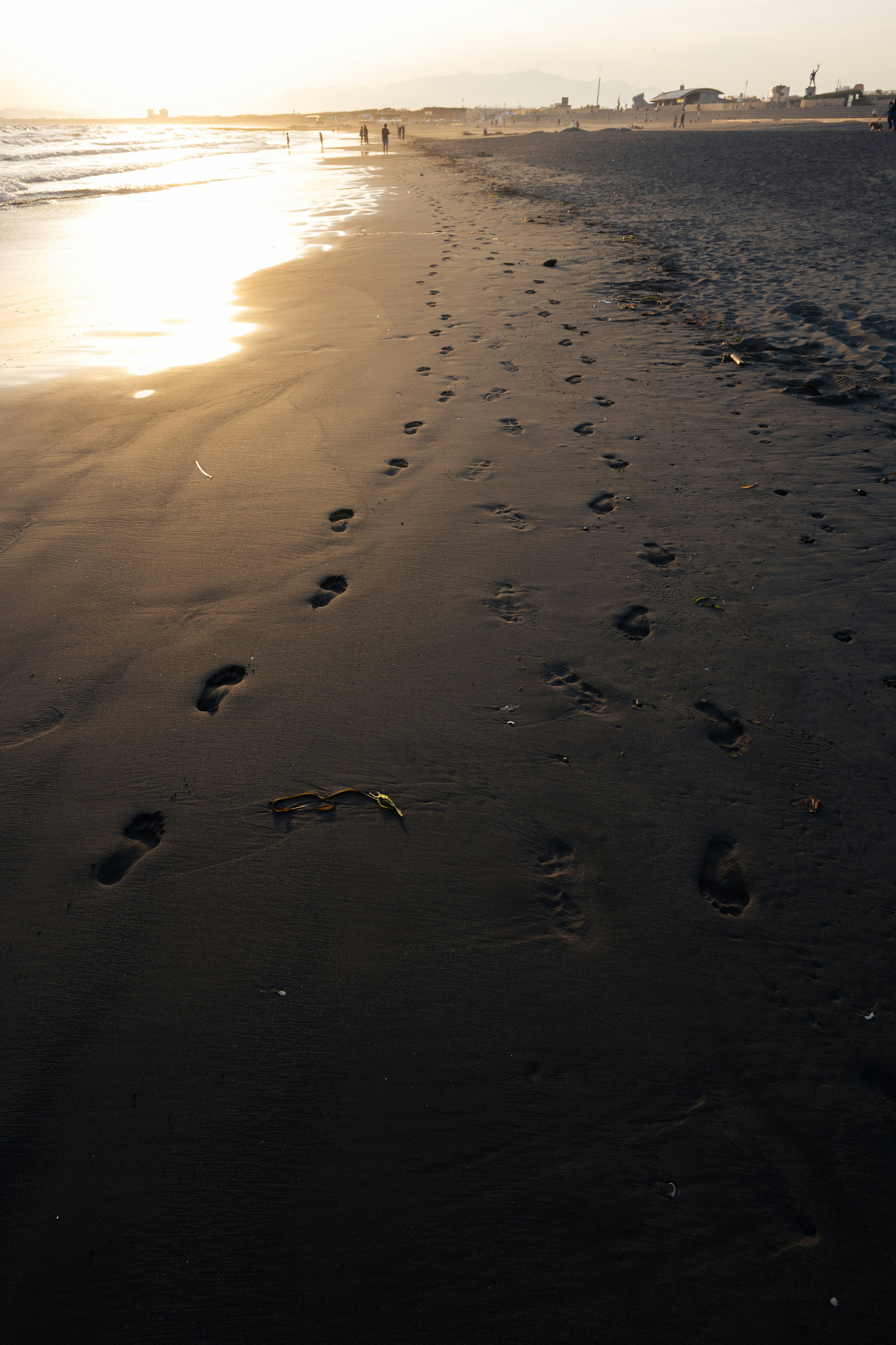 夕阳照耀的海滩沙地与脚印小径