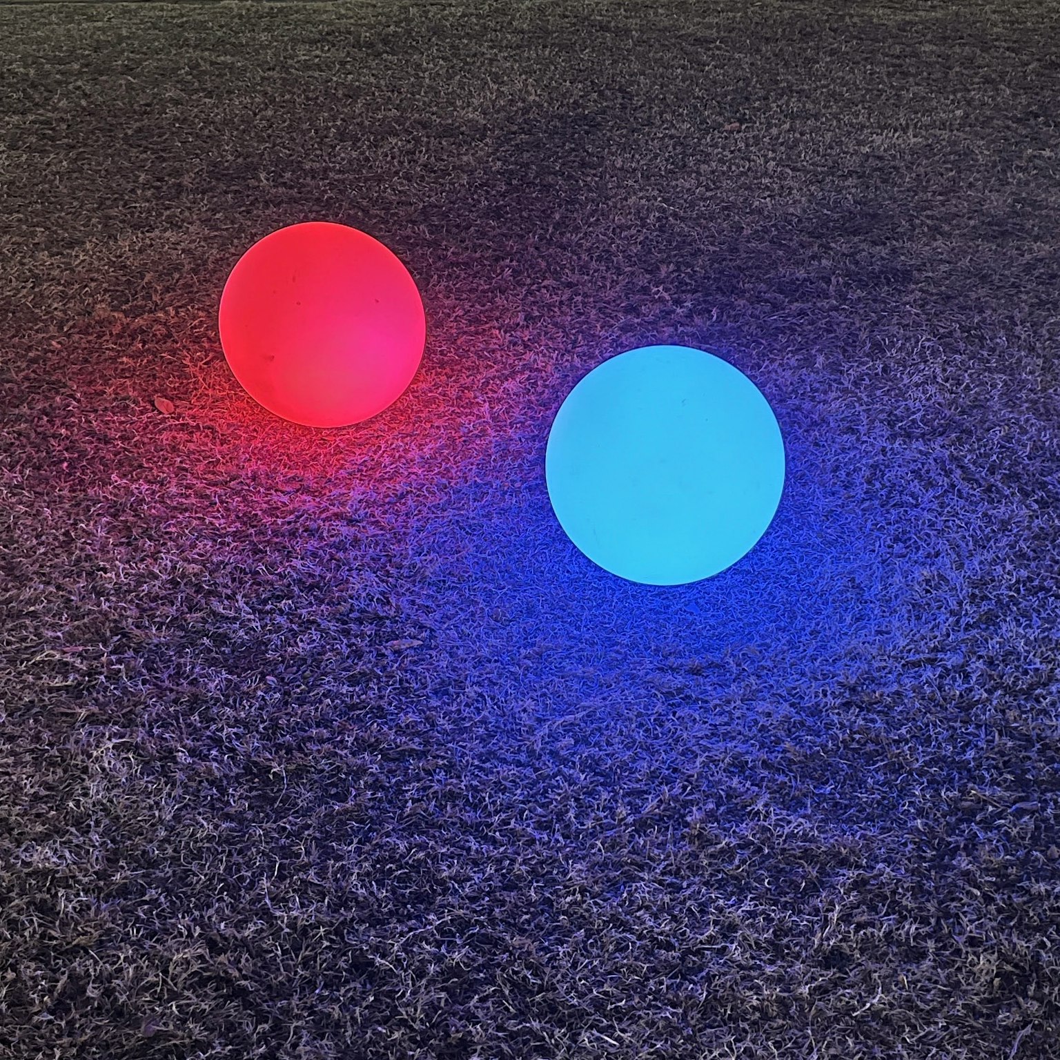 Esferas brillantes rojas y azules colocadas en el suelo