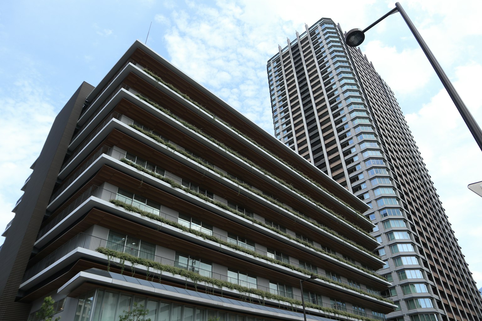 Photo featuring a modern building with balconies and a tall skyscraper