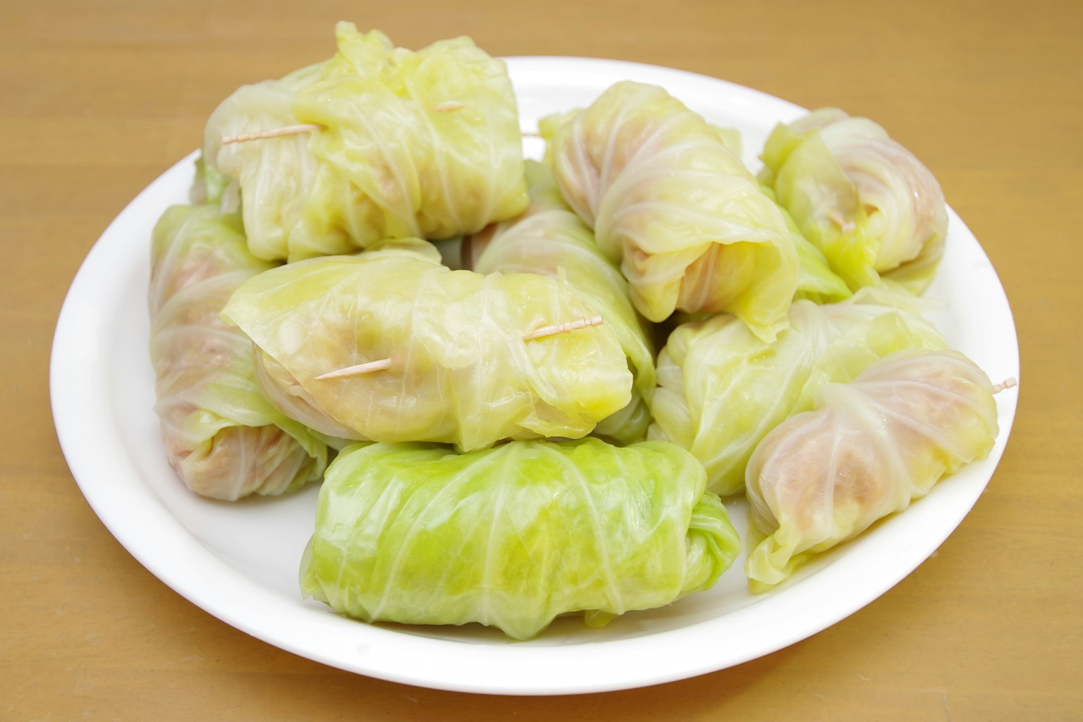 盤子裡裝著肉餡和包裹在高麗菜葉中的高麗菜捲