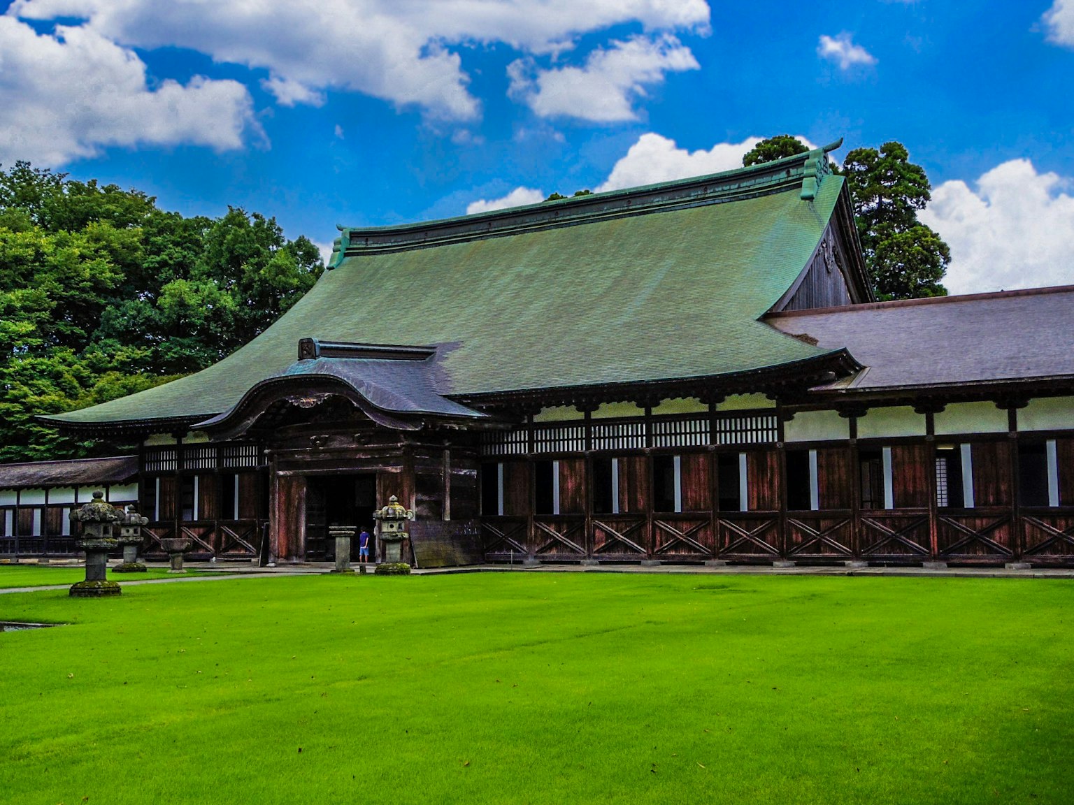 Bâtiment japonais traditionnel sous un ciel bleu avec une pelouse verte