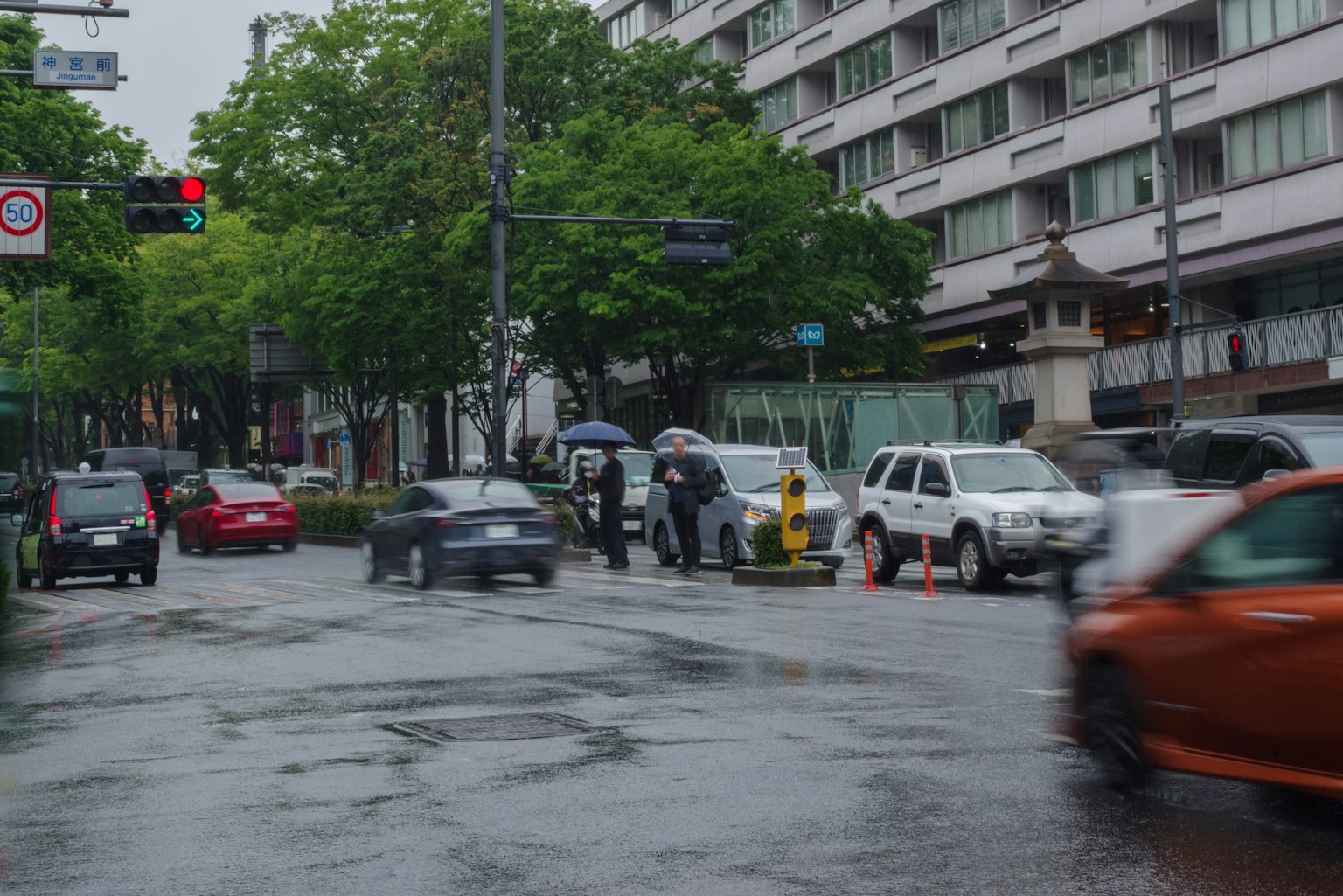 Busy intersection with pedestrians and vehicles in the rain