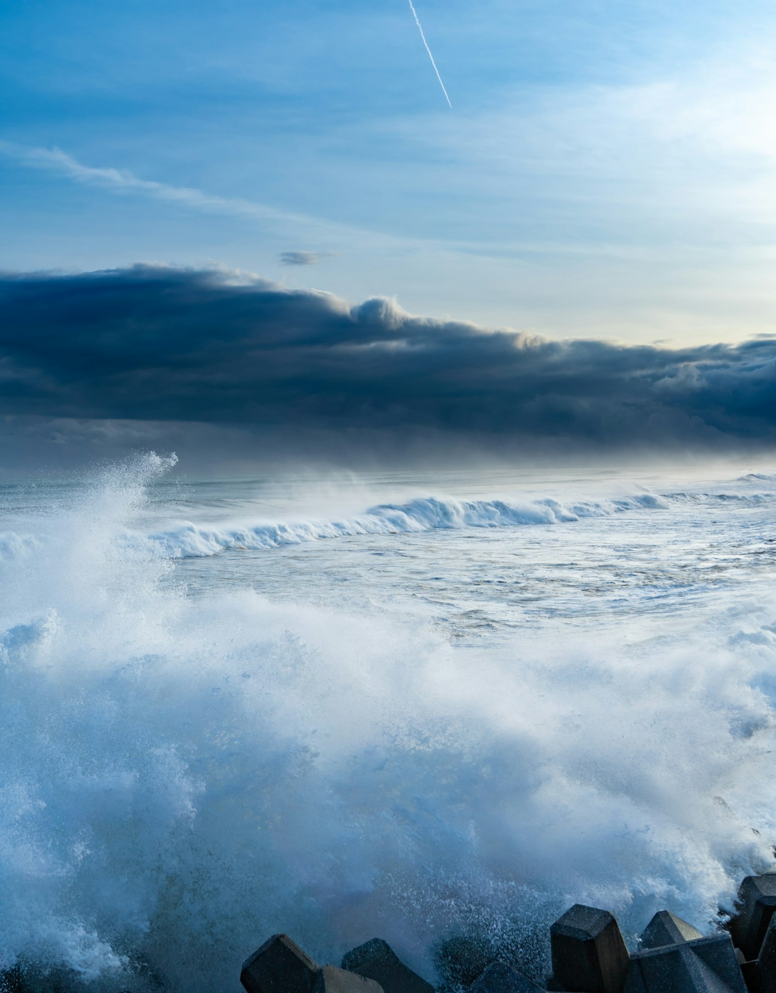 Onde che si infrangono contro le rocce sotto un cielo drammatico