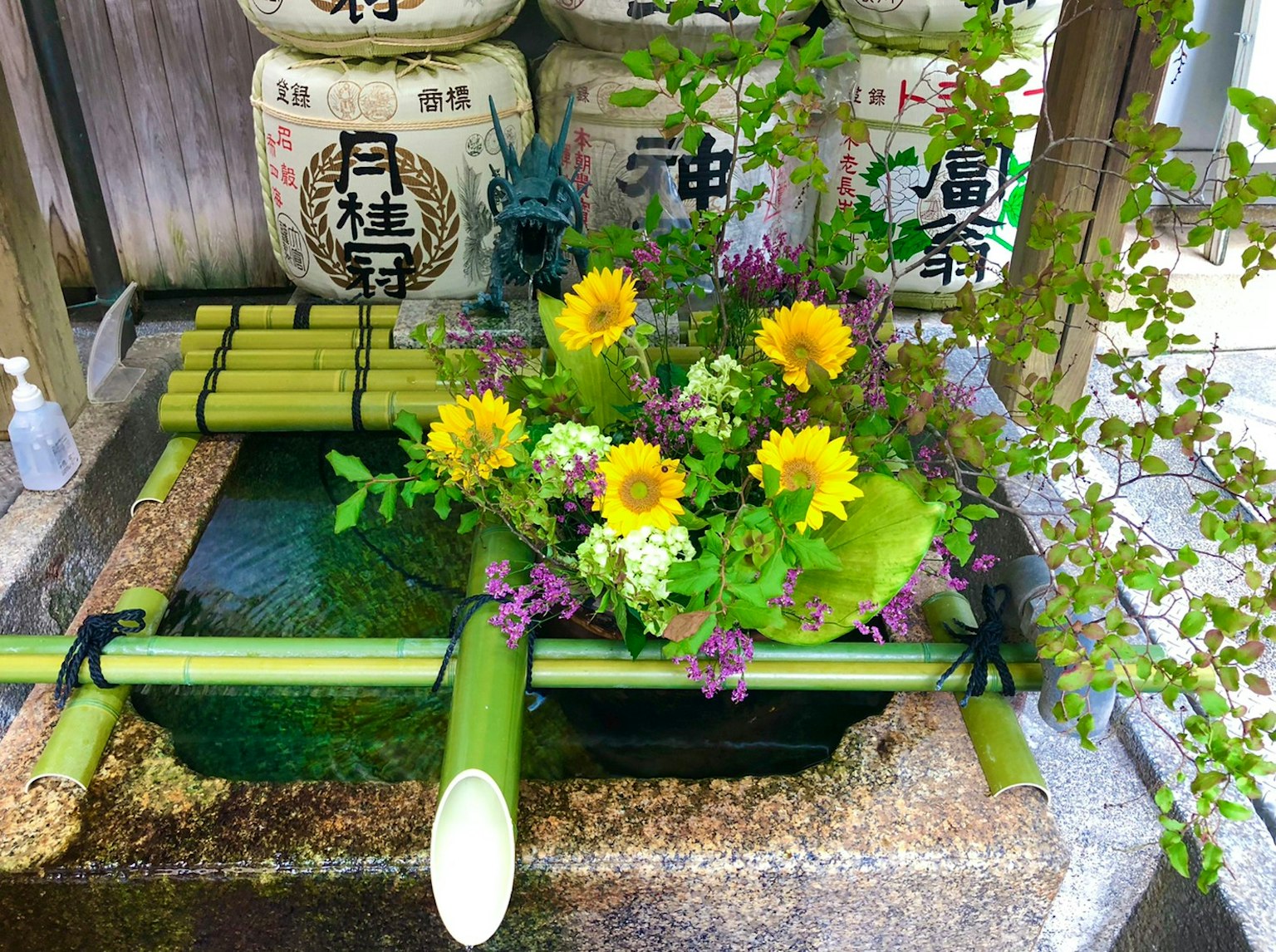 Un arrangement en bambou avec des tournesols près d'une fontaine