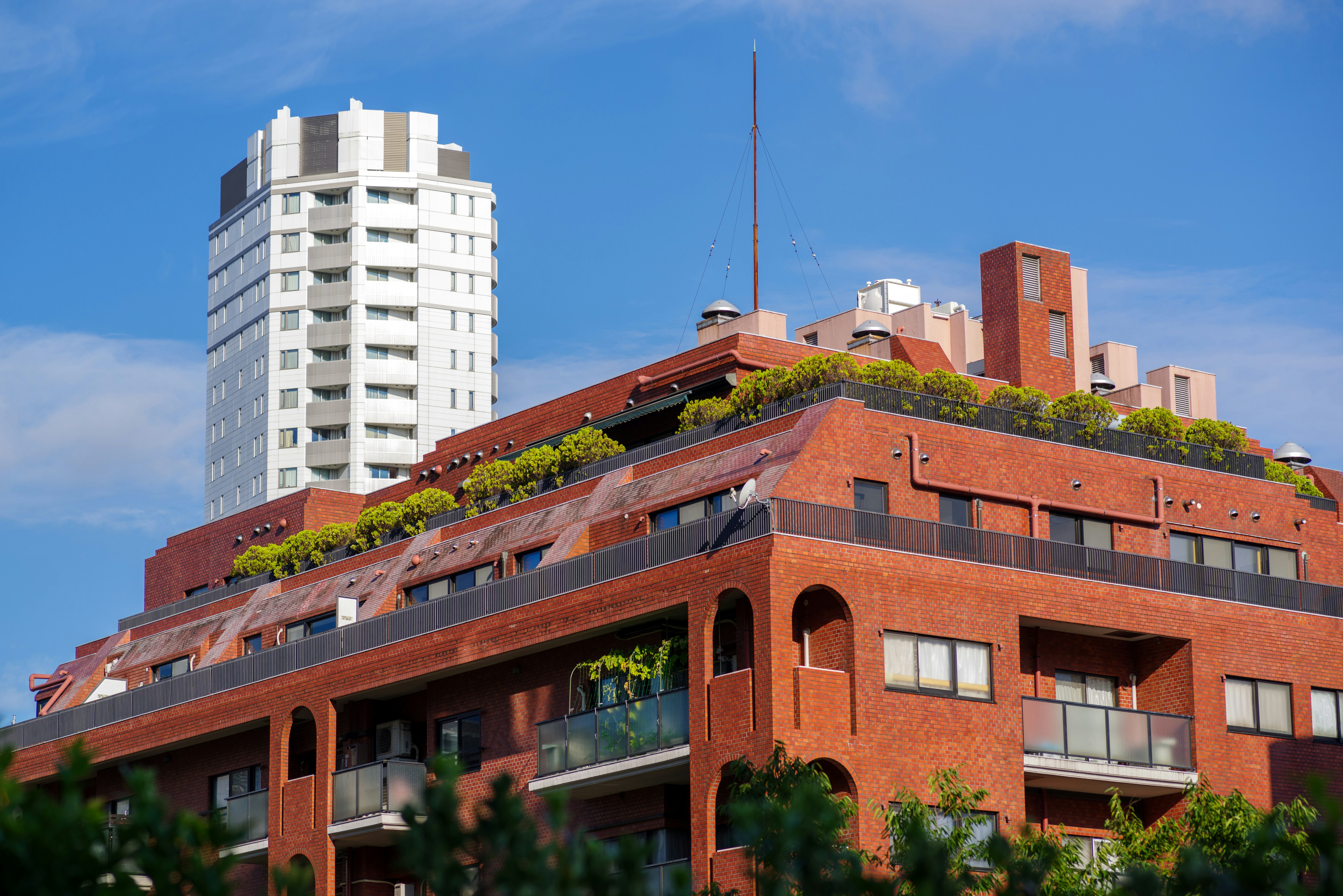 red-brick building with rooftop greenery in an urban scene