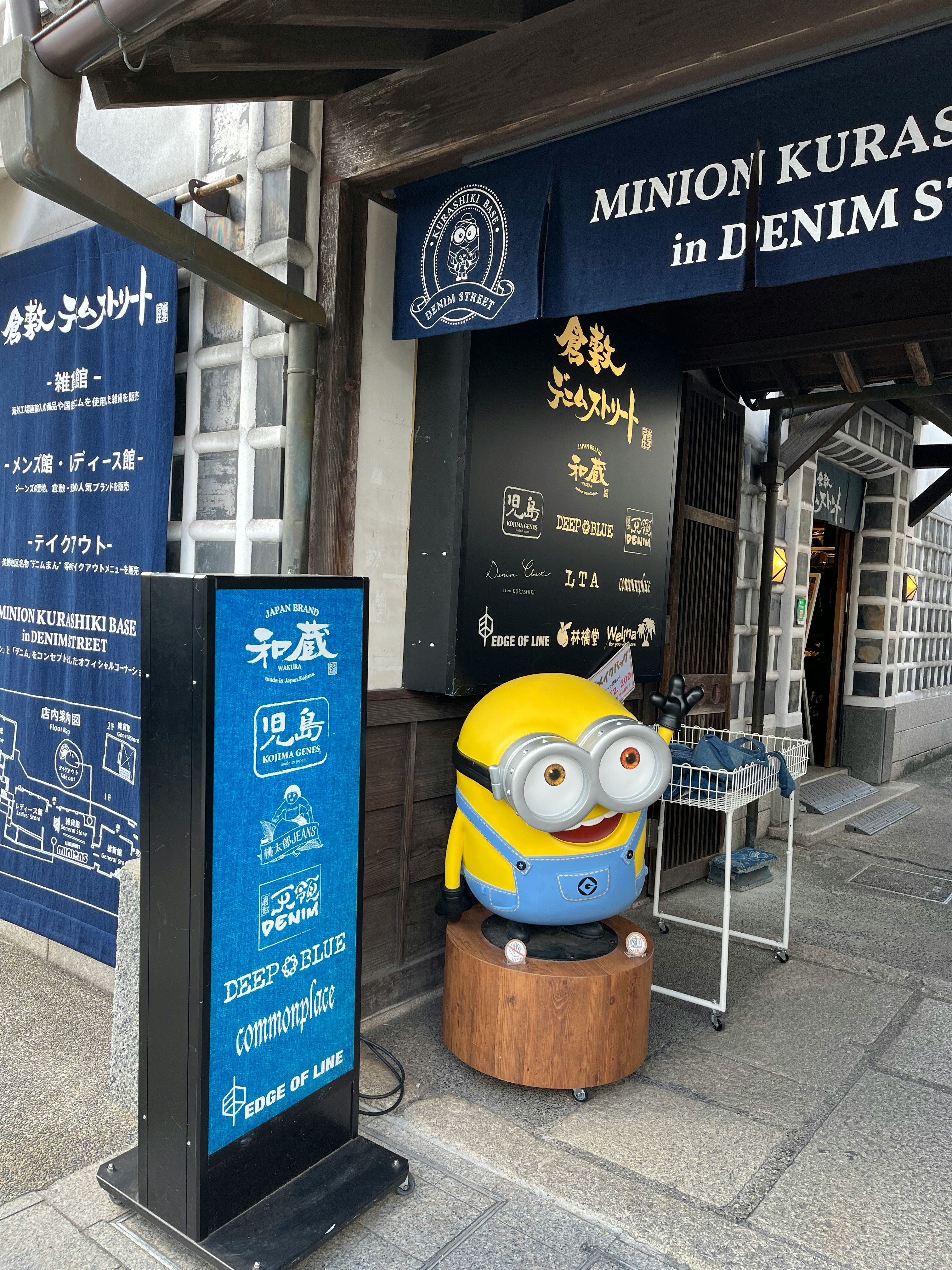 Minion character figure and storefront signs at a narrow alley entrance