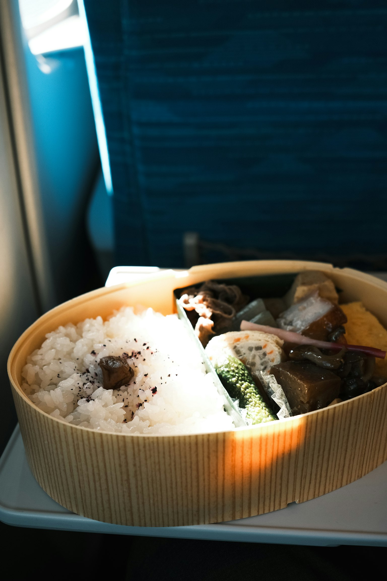 Photo d'une boîte à bento dans un avion avec du riz blanc et divers plats